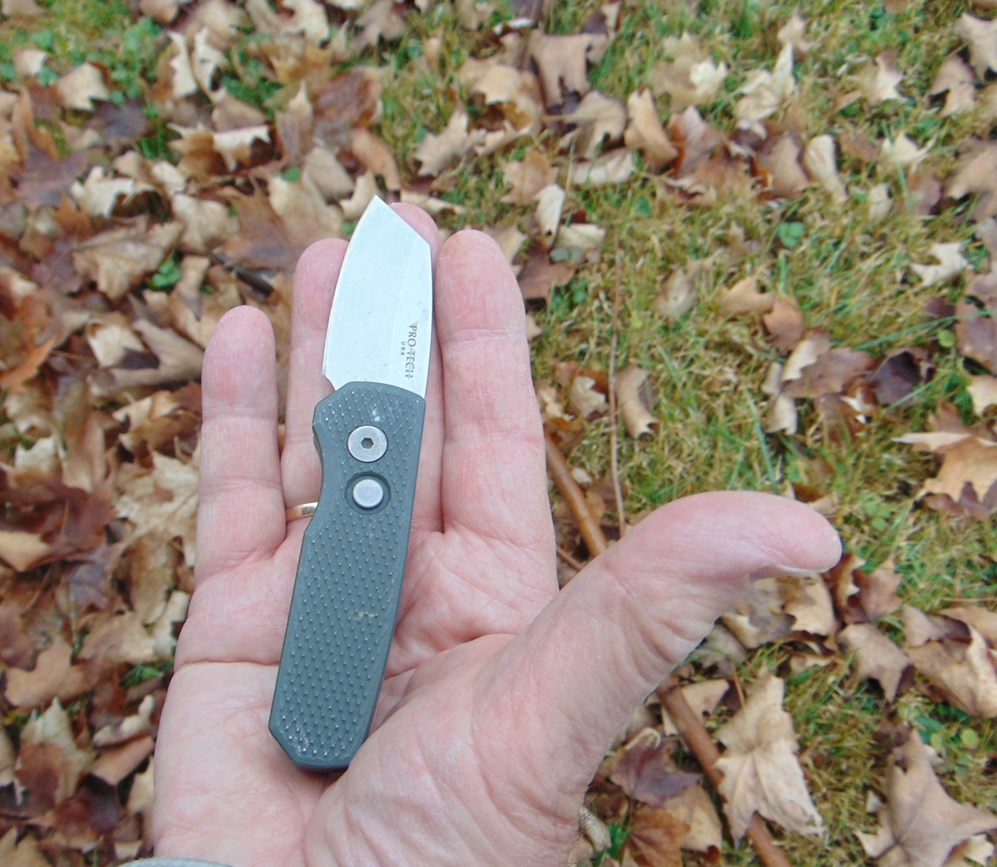 In this photo, the author demonstrates the size of the Runt 5. The black-anodized aluminum handle can be had with aluminum scales that are not too thick making it easy to maneuver while still keeping it secure when locked open. The matte finish, most people agree, won't accidentally rub off. It's easy to clean and it's also a better user experience than polymer handles found on some cheaper knives.
