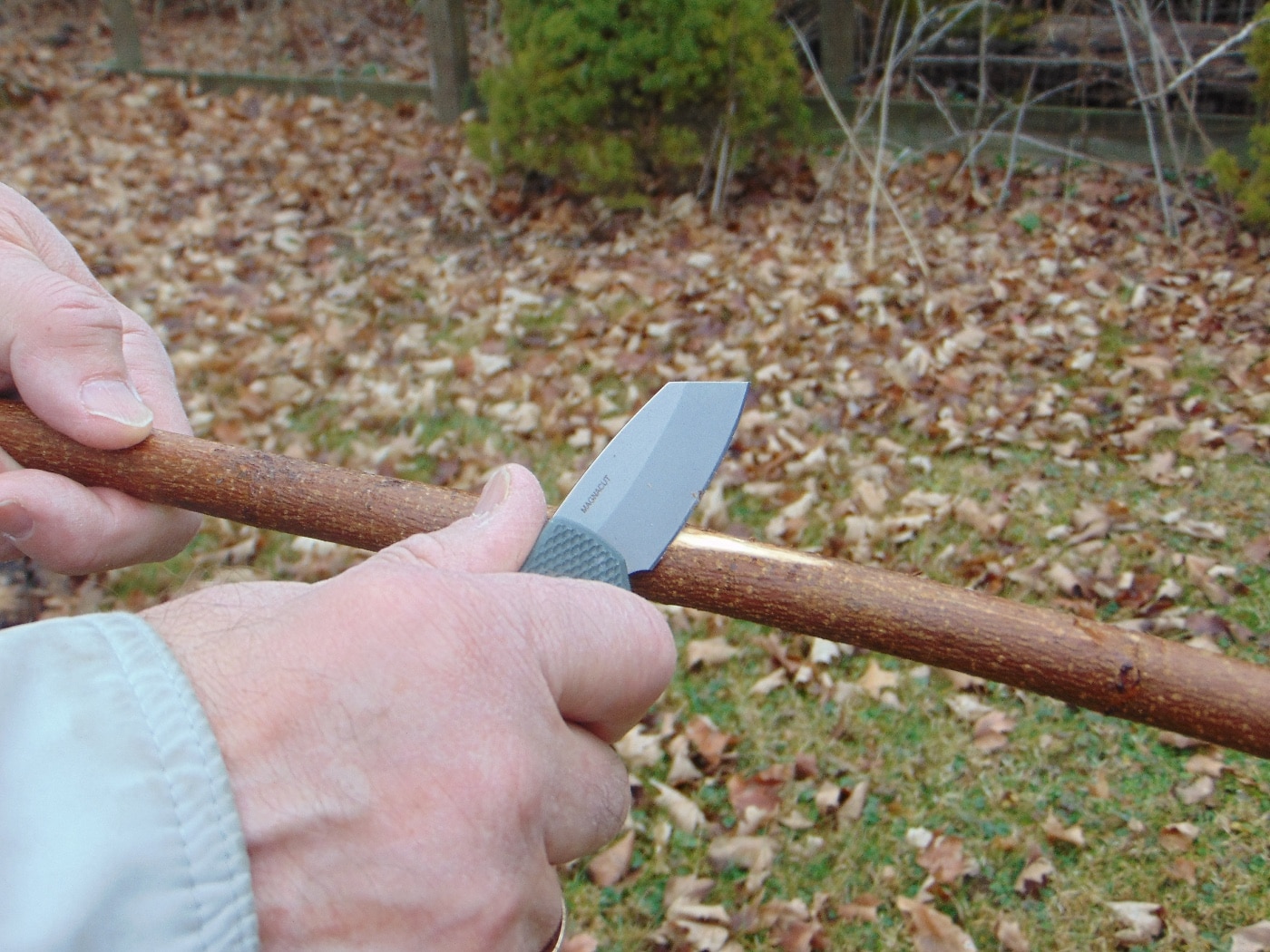 In this image, the author is skinning a sapling with the Runt 5 automatic knife. In his niche market, there are a lot of knives from companies like Benchmade, CRKT and Spyderco. Nevertheless, this automatic knife textured black model uses the latest magnacut steel as the newest take on their classic knife. The pocket-friendly auto comes with a CPM-20CV blade that's especially strong along the spine. Welcome to the blade club.