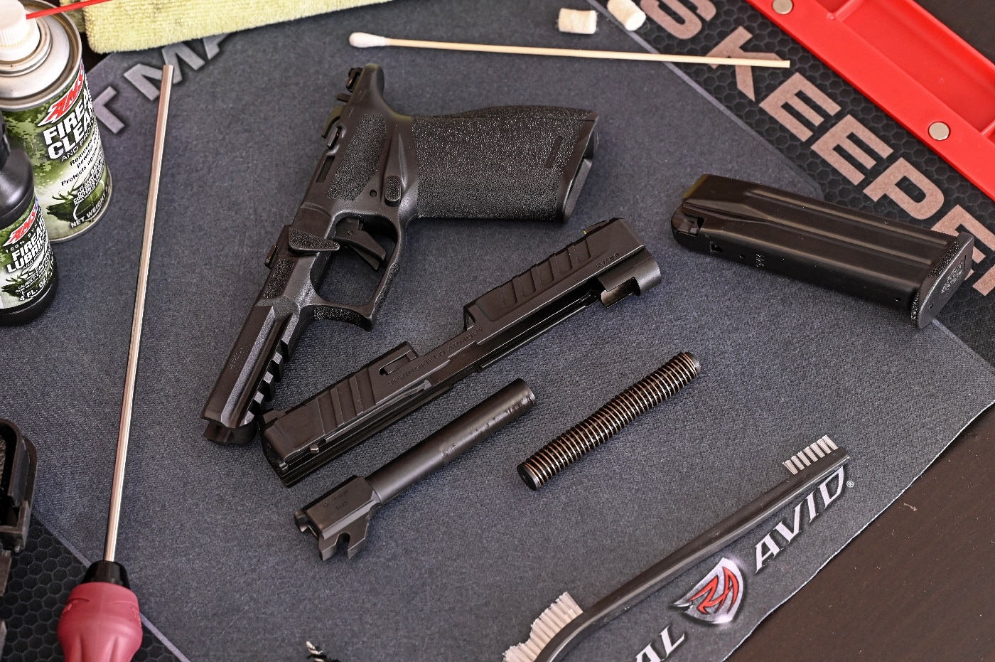 The author shows how he uses a cleaning mat in this photograph. The Real Avid cleaning mat prevents gun cleaner from leaking through to your table top. When you need to clean your pistol, the mat can help prevent damage to the table surface from a metal guide rod or other parts of your gun. If you do not have a dedicated mat, consider using a thick, clean cloth when you are ready to clean your firearm. 