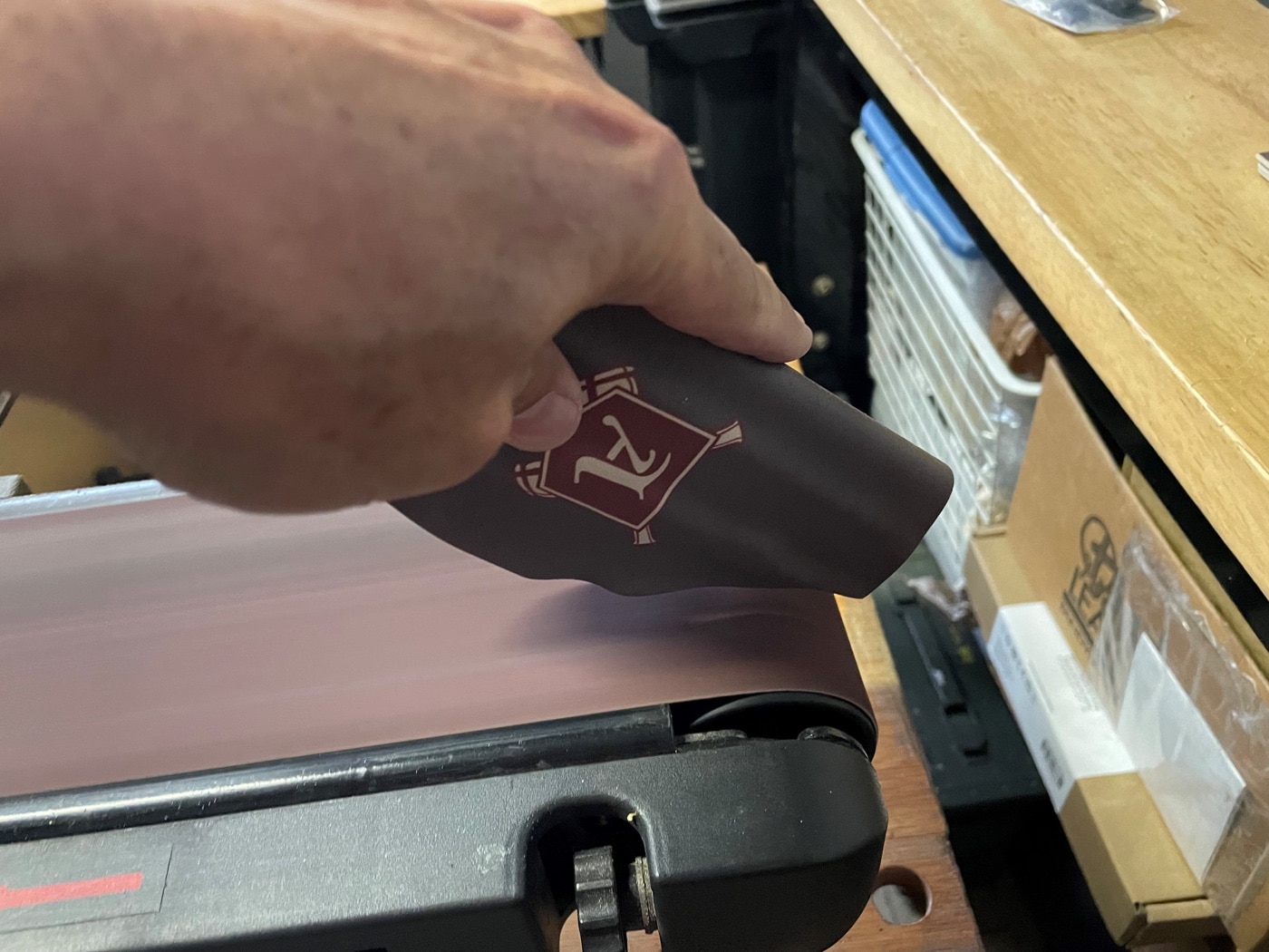 In this photo, the author is evening the sides of the holster using a bench sander. This took less than 10 minutes to shape things the way he wanted them. He followed on with hand sanding to get the right shape and feel to the edges. By now, the holster should be cool and rigid. If it is not, allow it to cool completely before sanding.