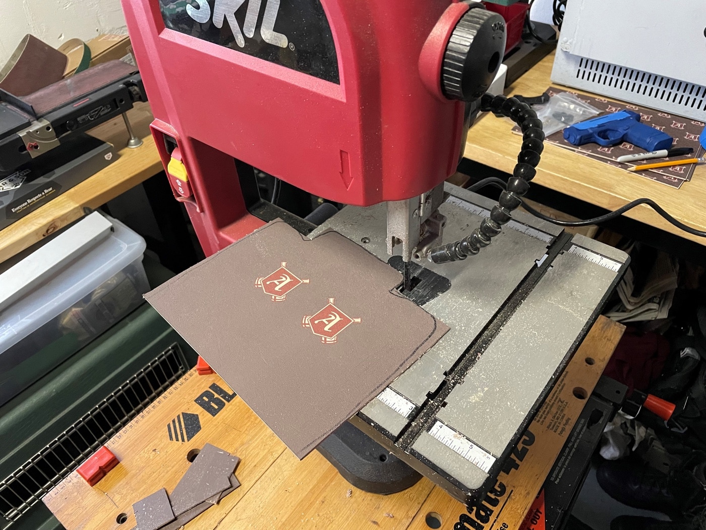 In this photo, the author is using a Skil brand band saw in his garage workshop to trim the Kydex to size. Before you stick the Kydex in the over, it is helpful to trim it to size for an easier fitting process. Be sure to leave a little extra space around your holster in case your measurements are not precise. This extra material will be easy to remove once the rig is molded around the handgun.