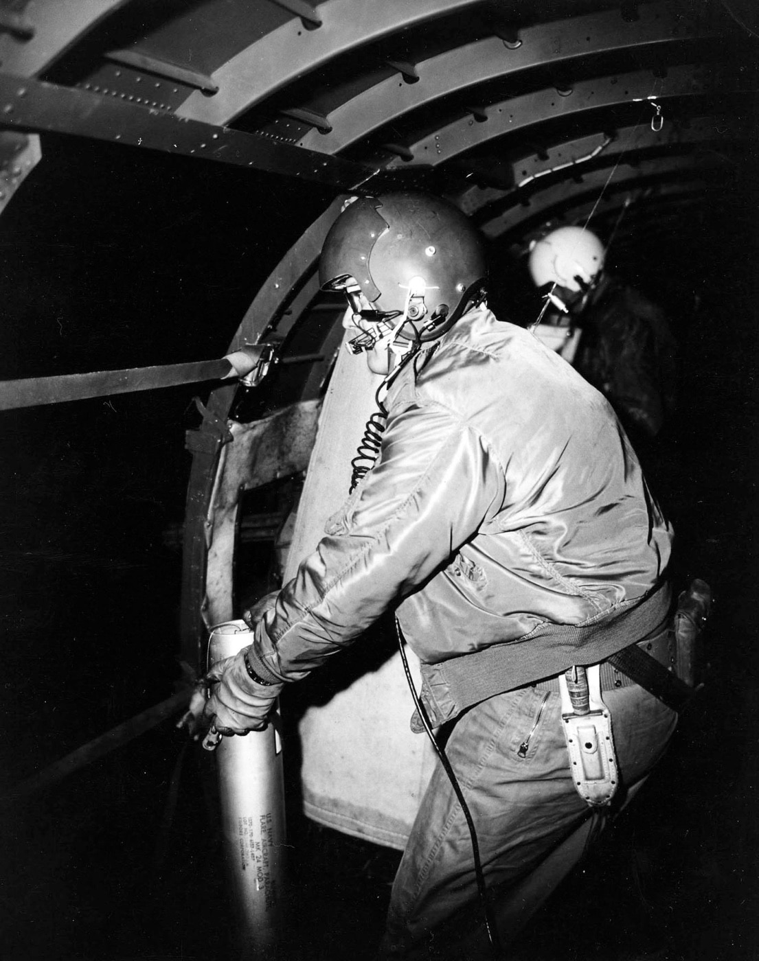 This photo is of an AC-47 gunner in the rear of the aircraft. He is preparing to drop a military illumination flare from an AC-47 aircraft. In the time before the widespread use of night vision equipment, adding light to the night was the only way Americans could see the enemy. A flare, also sometimes called a fusée, fusee, or bengala, bengalo in several European countries, is a type of pyrotechnic that produces a bright light or intense heat without an explosion.