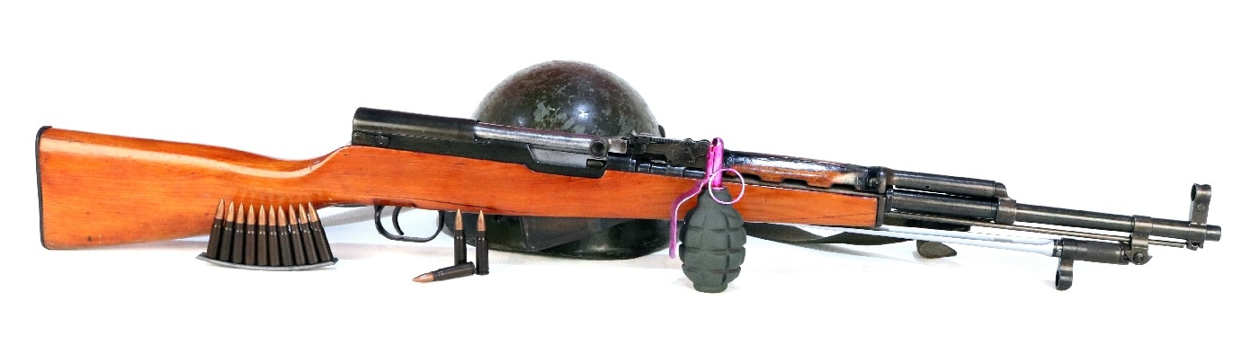 Shown in this digital photograph is a Chicom Type 56 SKS rifle in the author's collection. It is shown with 7.62x39mm ammunition and a dummy grenade. The 7.62×39mm round is a rimless bottlenecked intermediate cartridge of Soviet origin. The cartridge is widely used due to the worldwide proliferation of Russian SKS and AK-47 pattern rifles, as well as RPD and RPK light machine guns.