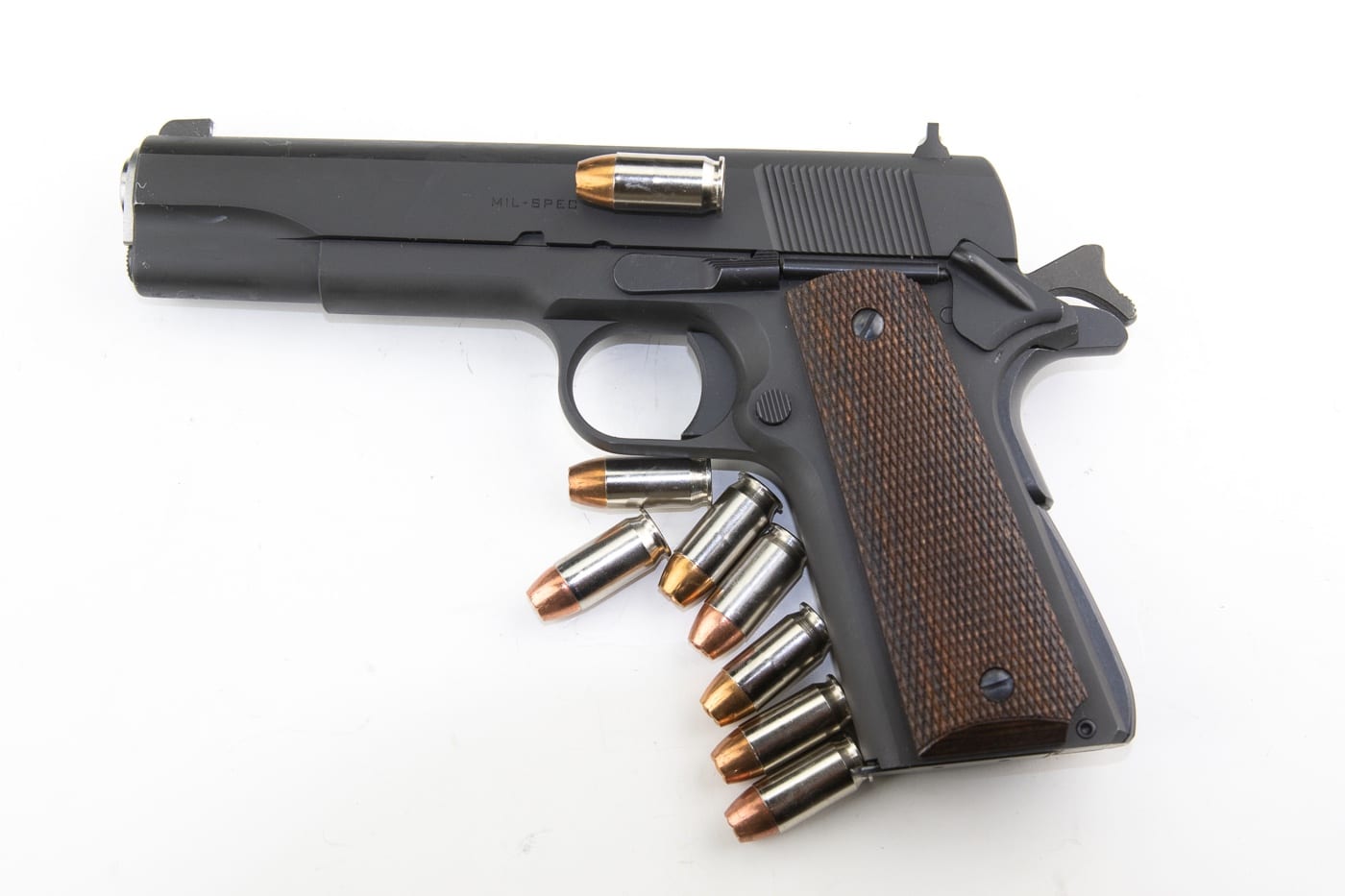 In this image, the author placed .45 ACP ammunition around the gun to represent carry in condition 1. The author recommends the use of the 1911 pistol in this mode with one in the chamber and the hammer cocked with the safety on. The manual safety is deactivated when the pistol is drawn.