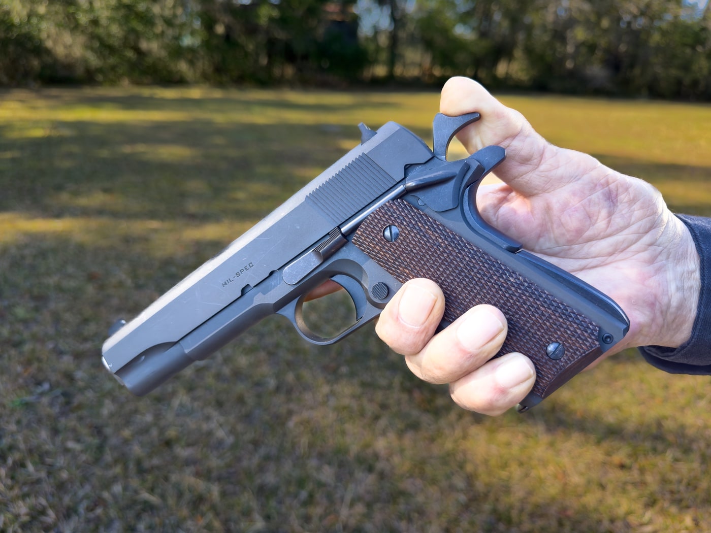 In this photo, the author is holding a Mil Spec M1911A1 and is cocking the hammer by hand. He shows how you have to break your grip to thumb the hammer back. The hammer must be cocked to fire the pistol. Carrying the M1911A1 is perfectly safe when cocked and you use the thumb safety. Nevertheless, Condition 2 carry adds another lever of defense to unintentional discharges.