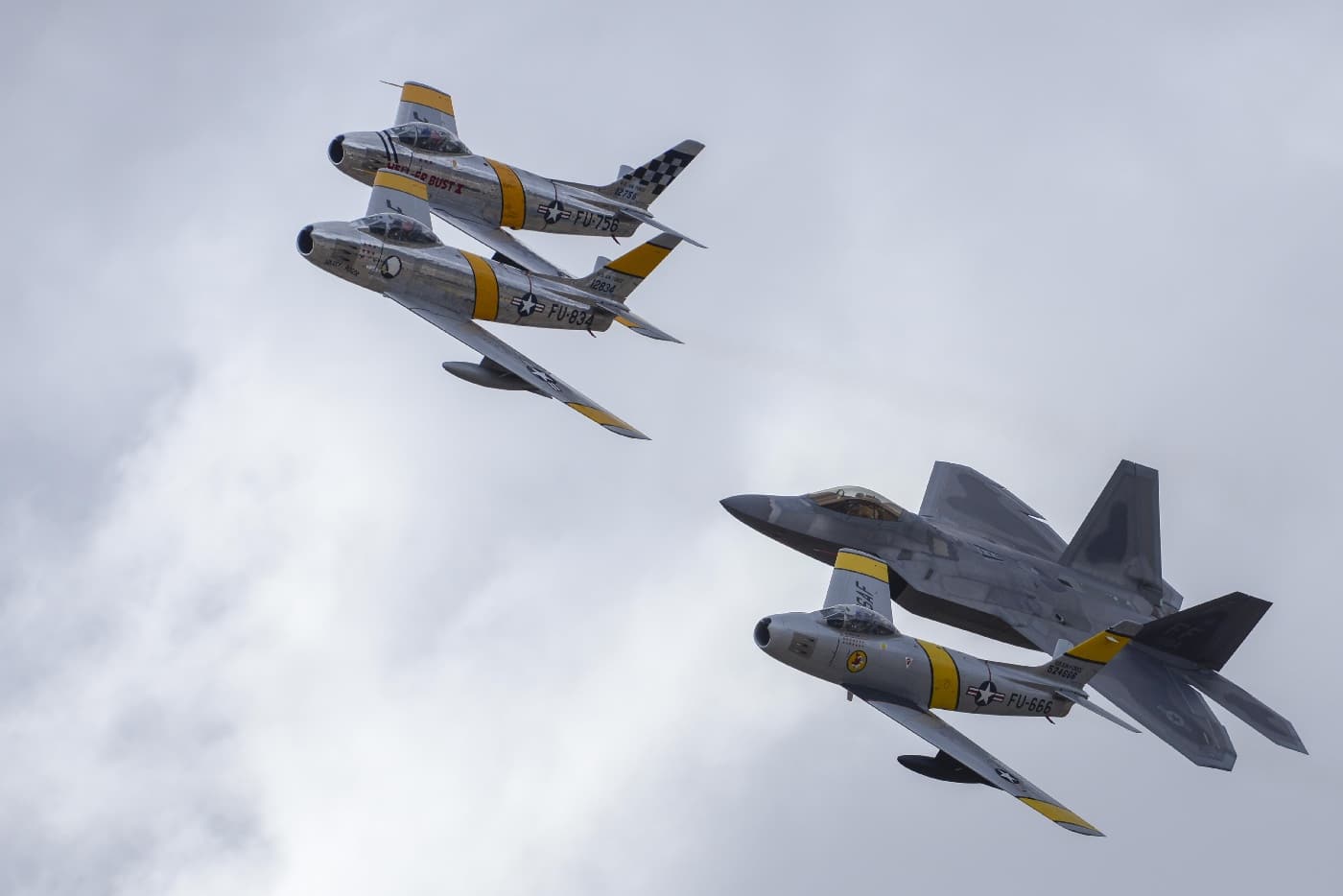 In this image, three F-86 fighters fly formation with an F-22 Raptor. The F-86 populates many an air museum while the F-22 is a front line fighter in current service. The Sabre proved versatile and adaptable, just as the F-22 is showing it is today.