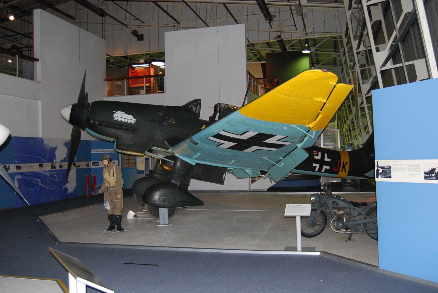 In this image, we see one of the two restored Ju 87 Stuka dive bombers left in the world. This one is in the Royal Air Force Museum. The Royal Air Force Museum London is located on the former Hendon Aerodrome, in North London's Borough of Barnet. It includes five buildings and hangars showing the history of aviation and the Royal Air Force. It is part of the Royal Air Force Museum.