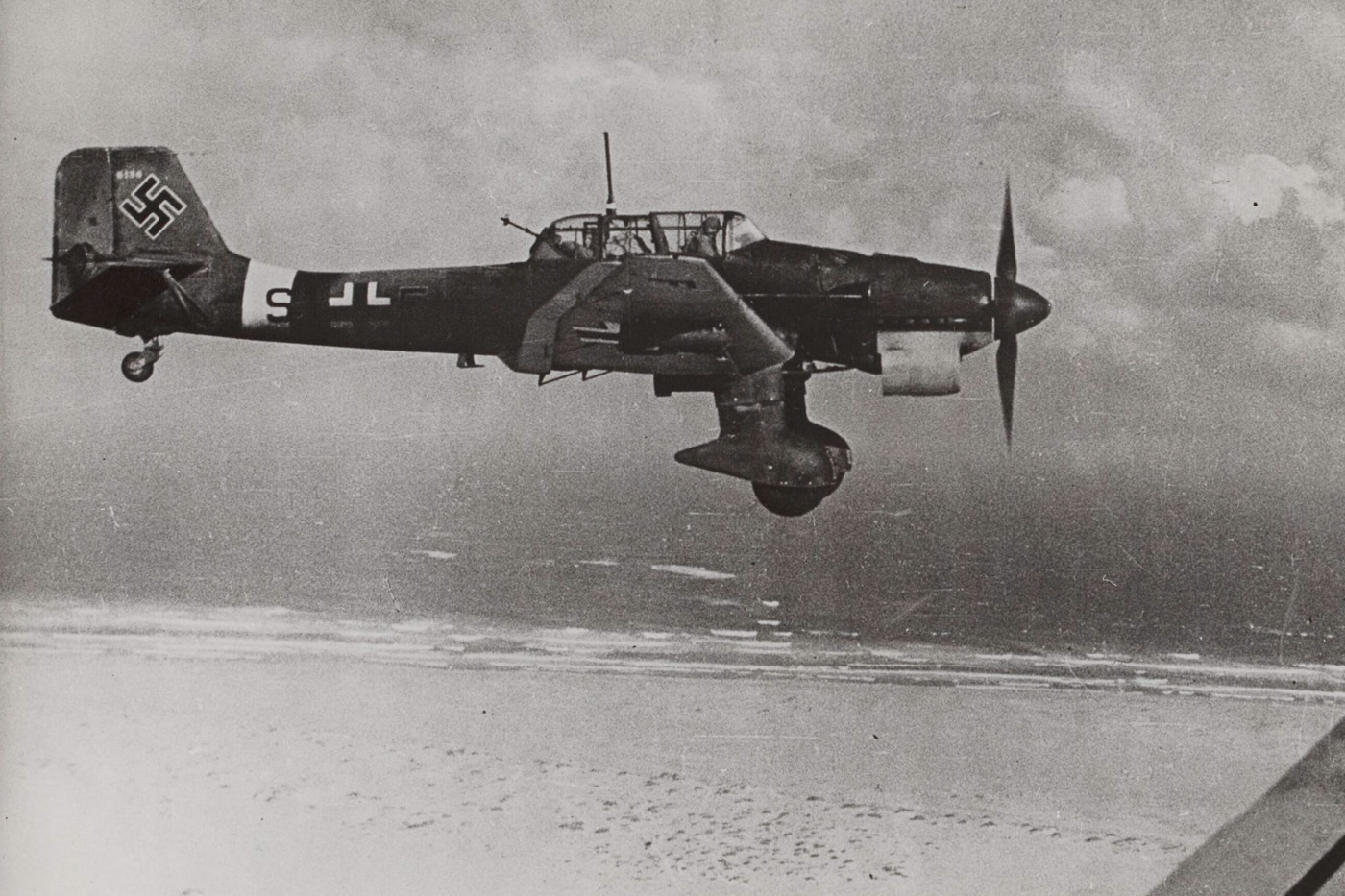 In this digital image we see a German Stuka in flight above a North African beach on the Mediterranean Sea. The North African campaign of the Second World War took place in North Africa from 10 June 1940 to 13 May 1943. It included campaigns fought in the Libyan and Egyptian deserts and in Morocco and Algeria, as well as Tunisia. Johannes Erwin Eugen Rommel was a German Generalfeldmarschall during World War II. Popularly known as the Desert Fox, he served in the Wehrmacht of Nazi Germany, as well as serving in the Reichswehr of the Weimar Republic, and the army of Imperial Germany.