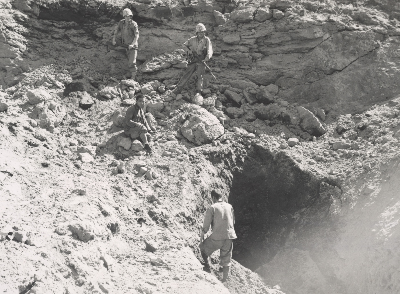 A Japanese POW (middle) tries to talk other Japanese soldiers out of caves. Image: U.S. Marine Corps