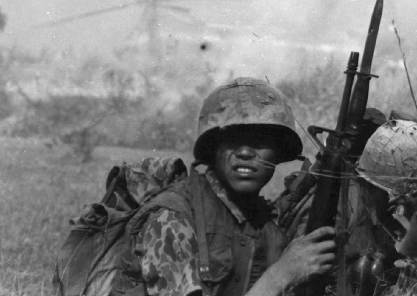 This photo shows a South Korea Marine of the Blue Dragons with a M16 rifle, bayonet, helmet and camouflage uniform. He is taking cover behind a hedgerow while waiting on an order from his sergeant to start the search and destroy mission looking for Viet Cong communists in South Vietnam.
