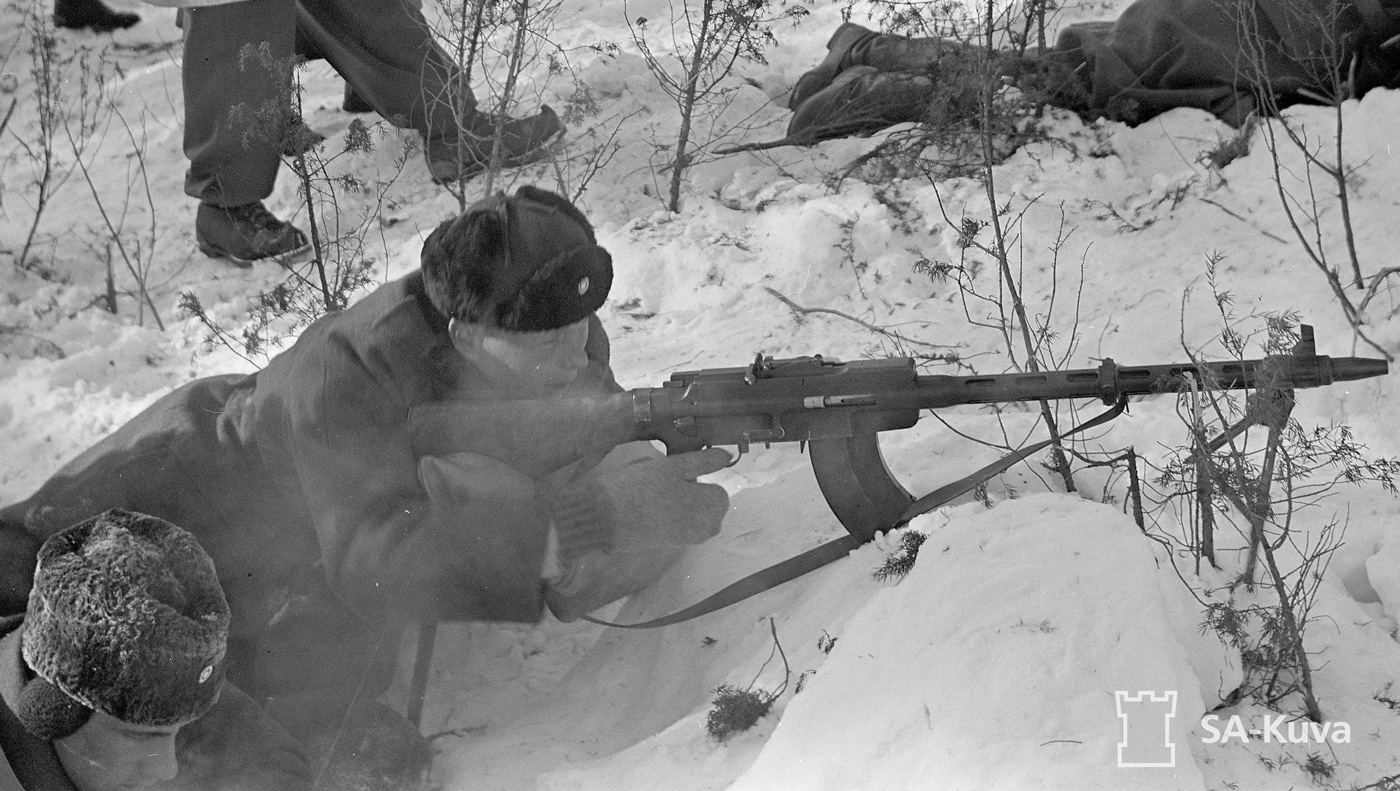 Shown in this photograph are Finnish troops training with the guns at the Järvenpää Educational Center. The Finnish Army seems to have given the Lahti-Saloranta the nickname of quick rifle. The firearm had many similar characteristics to the DP-27 Degtyarev light machine gun but with a more limited magazine capacity. It was chambered in the 7.62x53 cartridge, but would also fire 7.62 x 54 r round as well. A platoon was often equipped with two guns that each had a folding bipod and no less than two magazines. The 7.62×53mmR rifle cartridge is a Finnish design based on the Russian 7.62×54mmR round dating back to 1891.