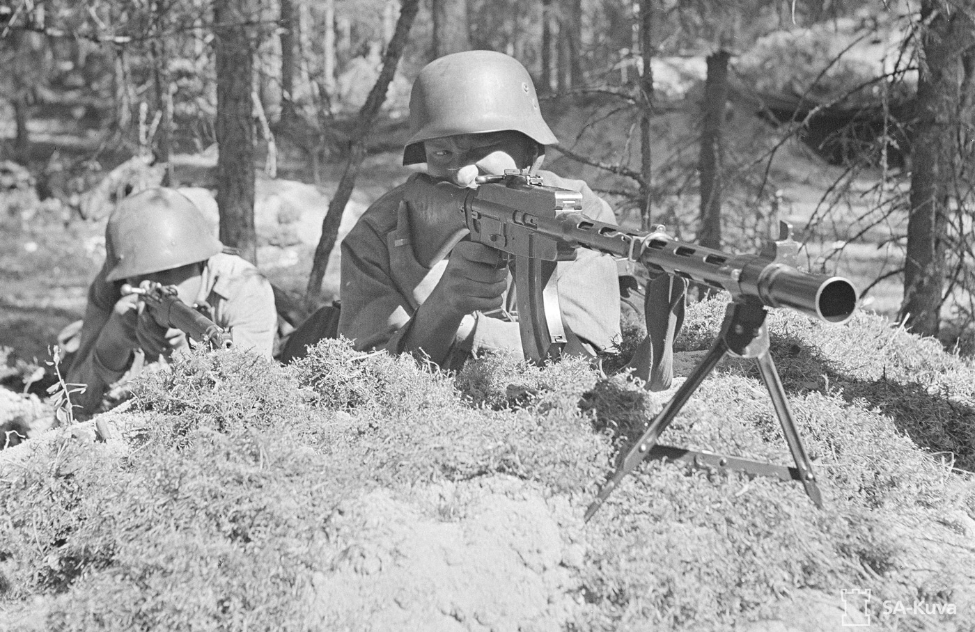 In this photo, we see two Finnish soldiers in defensive positions during the Continuation War circa 1942. One is armed with the Lahti-Saloranta M/26. 	The Lahti-Saloranta M/26 is a light machine gun which was designed by Aimo Lahti and Arvo Saloranta in 1926. The weapon was able to fire in both full automatic and semi-automatic modes.