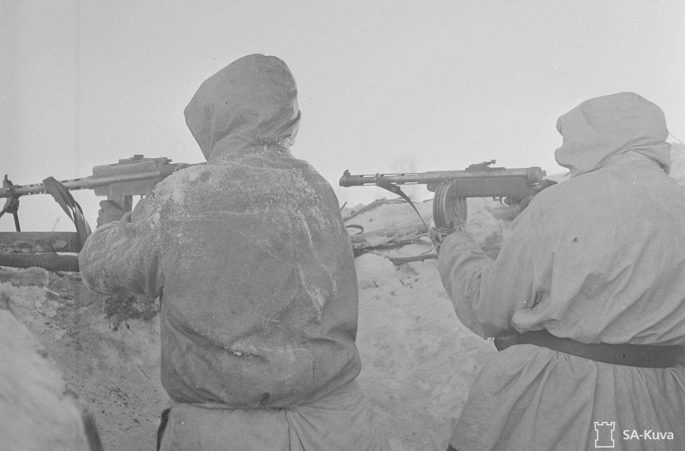Shown in this photographic image are two Finnish soldiers. The one on the left is shooting a M/26 while the one on the right is firing a KP/-31 SMG. Both of these guns were Lahti designs and were used extensively against the Red Army. The weapons were produced for the Finnish services.