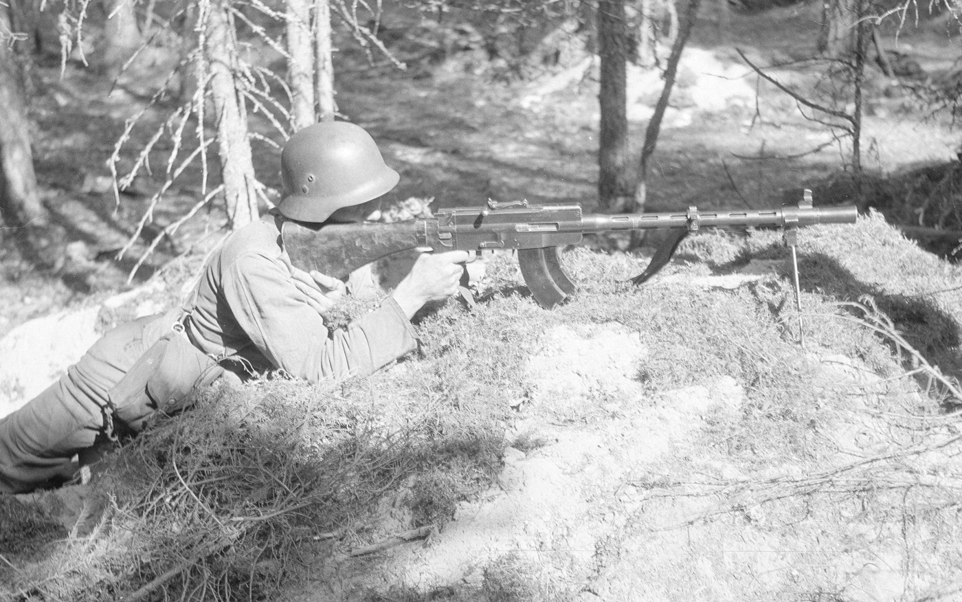In this photo, a soldier of the Finland Army assumes a prone defensive position with his machine gun to repel communist troops from the Soviet Union. The gun used a short recoil operation and automatic firing to produce a high firing rate. While the gun could come with a drum magazine, most Finnish troops were issued 20-round box-style magazines. The innovative design was largely in part due to Finnish inventor and co-designer Arvo Saloranta.