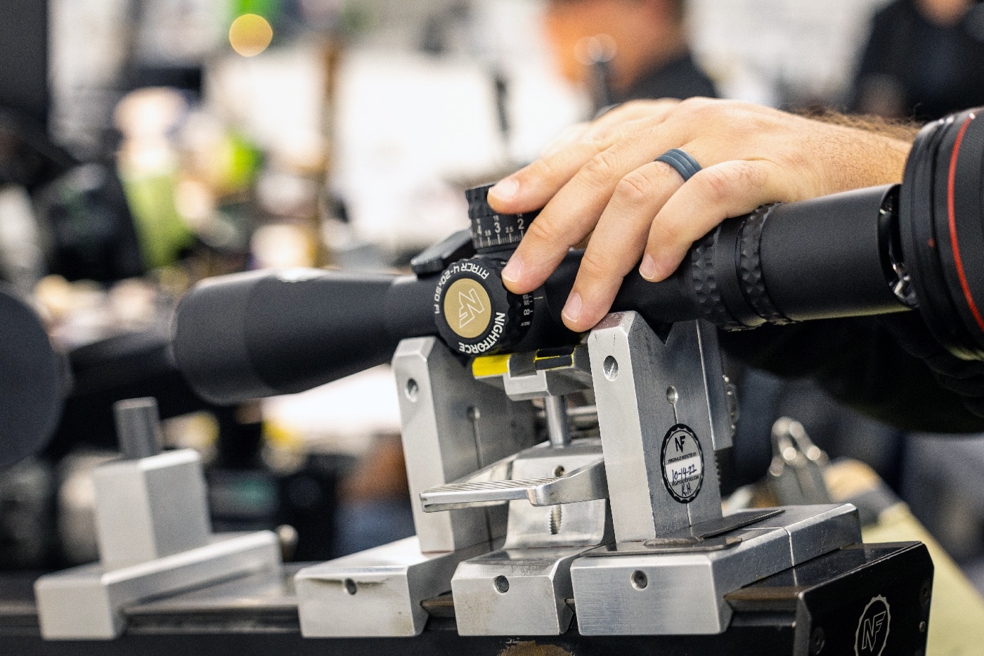In this photograph, we see a Nightforce Optics employee completing the assembly of a rifle scope.