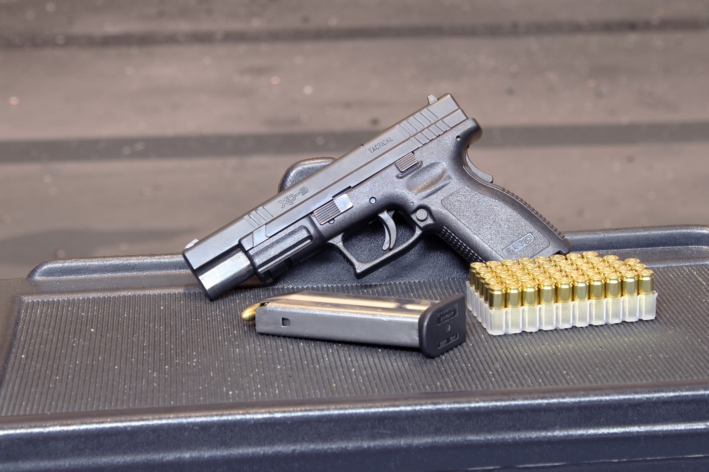 This image shows the Springfield Armory XD Tactical at the range with a loaded magazine and an ammunition box with 50 rounds of live handgun cartridges.