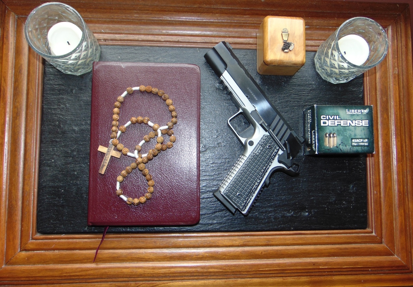 In this photo made by the author, we see his Springfield Armory Emissary 1911 .45 ACP pistol with a rosary and other items he carries when going to church. 