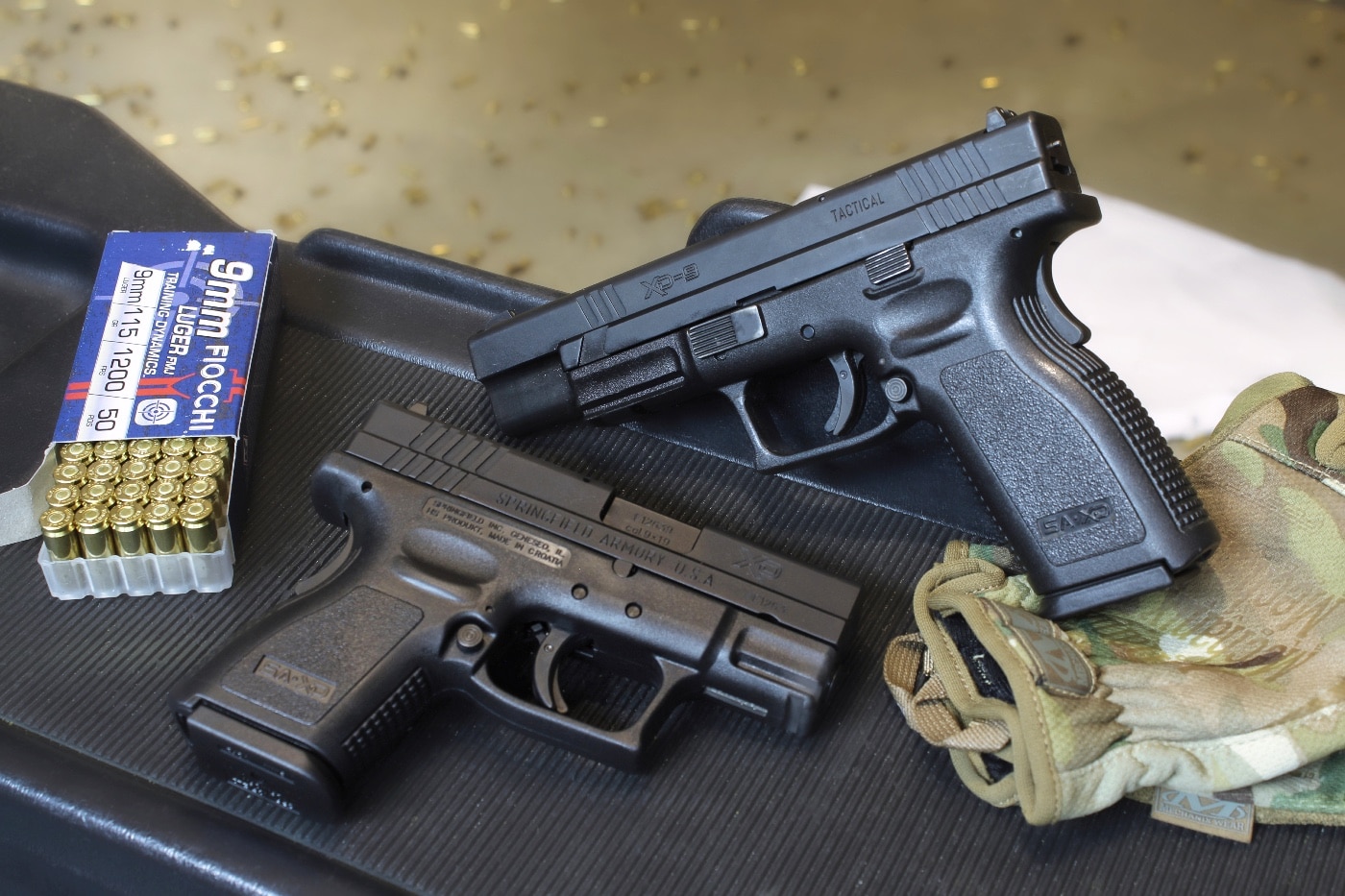 In this image, we see the Springfield Armory XD Tactical and the XD Subcompact pistols on a bench at a shooting range. These 9mm pistols offer excellent personal protection options.