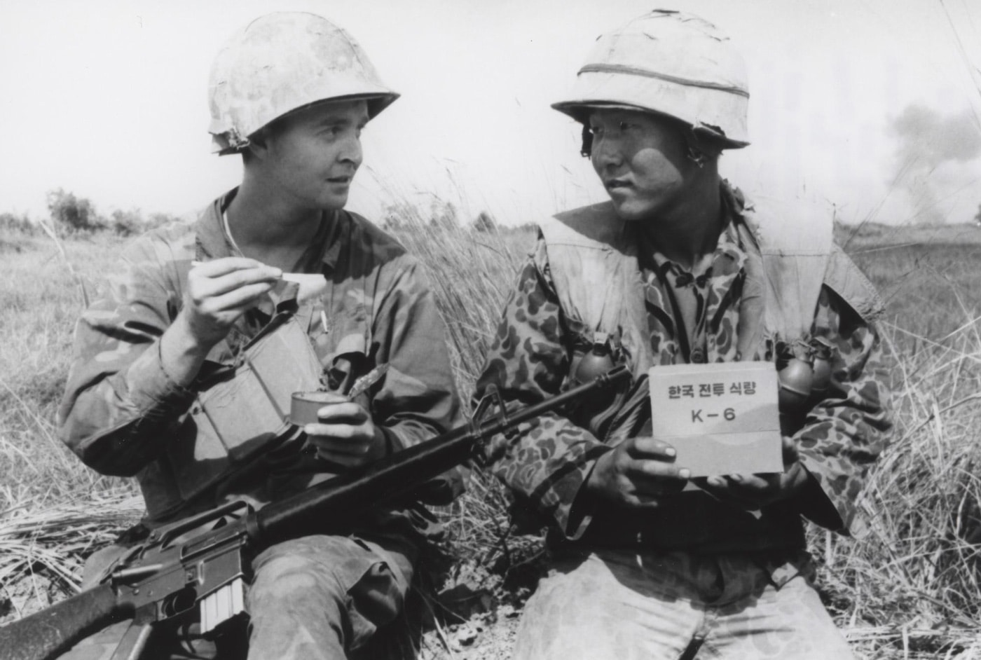 In this digital photo made from a film negative, US and Korean Marines swap military rations in the field during combat operations. The U.S. Marine has a M16A1 rifle on his lap. The South Korean Marine has a M26 grenade. The M26 is a fragmentation hand grenade developed by the United States military. It entered service around 1952 and was used in combat during the Korean War. Its distinct lemon shape led it to being nicknamed the "lemon grenade".