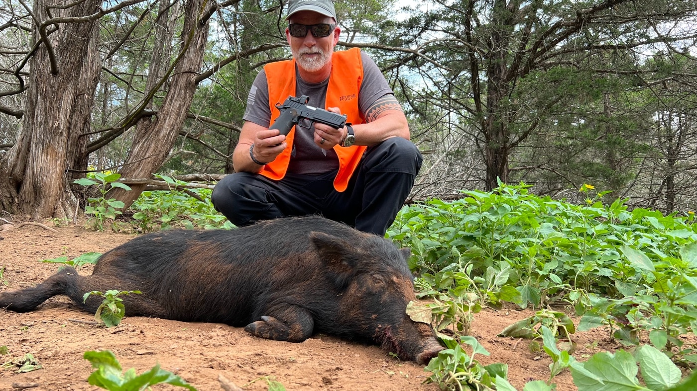 In this final photograph, we se the author posing with the hog he harvested using his Prodigy and 9mm Federal ammunition.