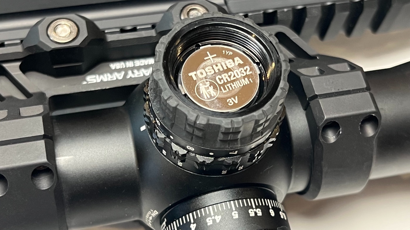 In this image, we see the end cap of one turret has been removed so the 3 volt button battery is displayed. While this scope doesn't qualify as military weaponry, it is a definite hunting and competition tool that is perfect for projectile weapons including modern sporting rifles, ar-15, lever action rifles and more.