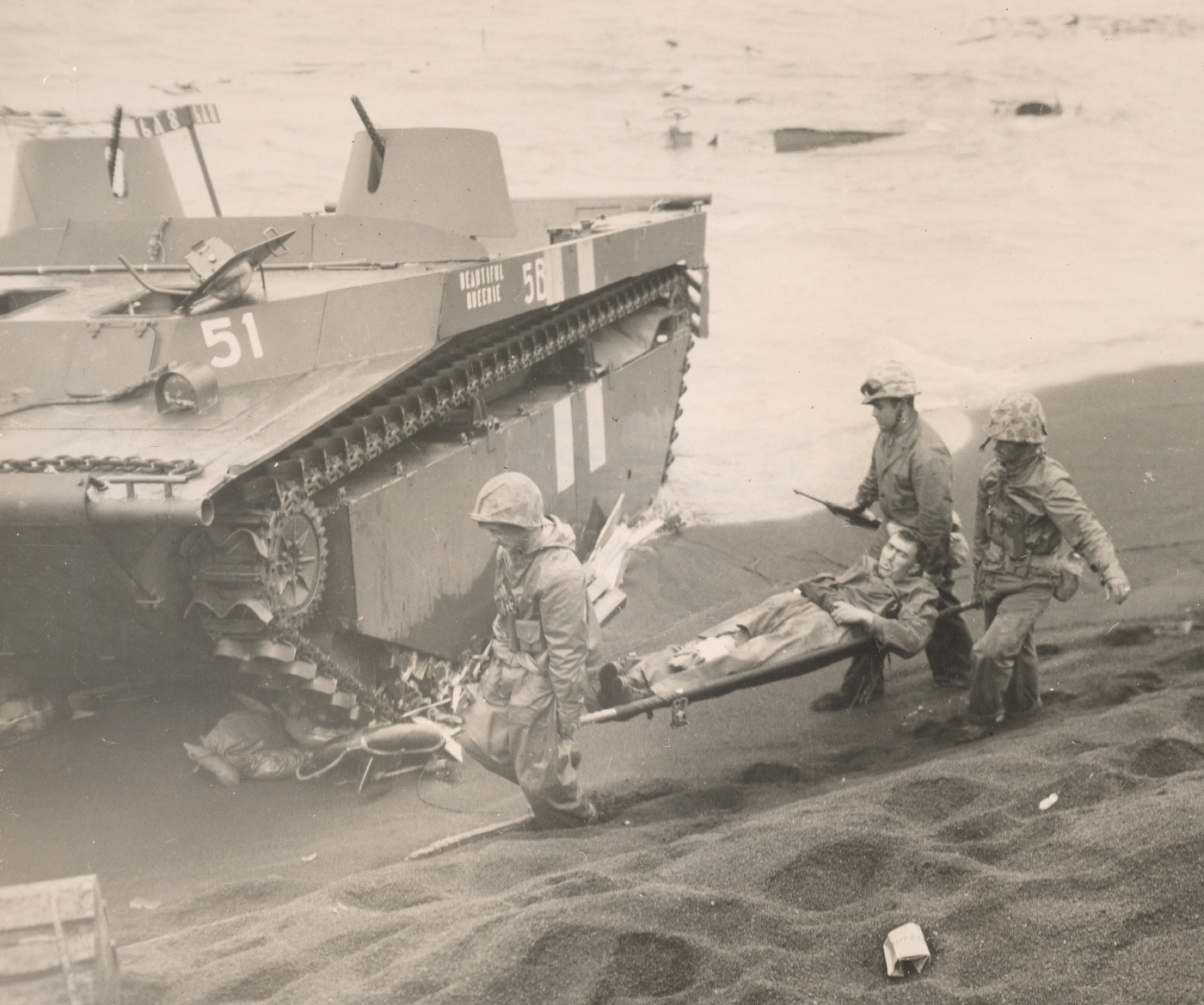 Three Leathernecks carry a wounded comrade to an evacuation point on the Iwo Jima beachhead. Image: Cpl. Eugene Jones/U.S. Marine Corps