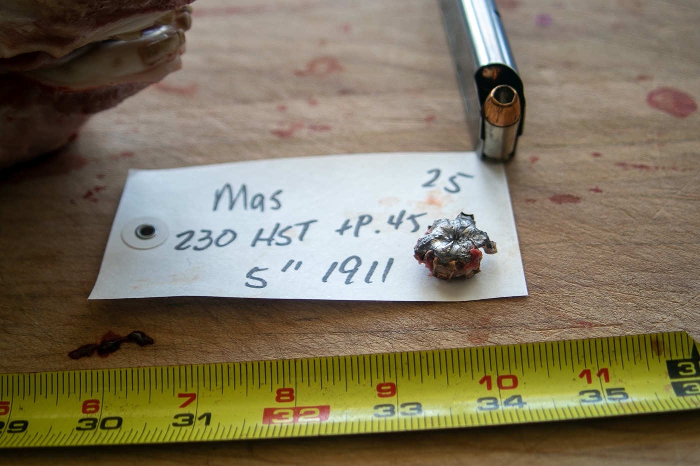 In this photograph, the author shows us a recovered .45 caliber expanded hollow point bullet that was used to harvest a wild pig during a hog hunt. 