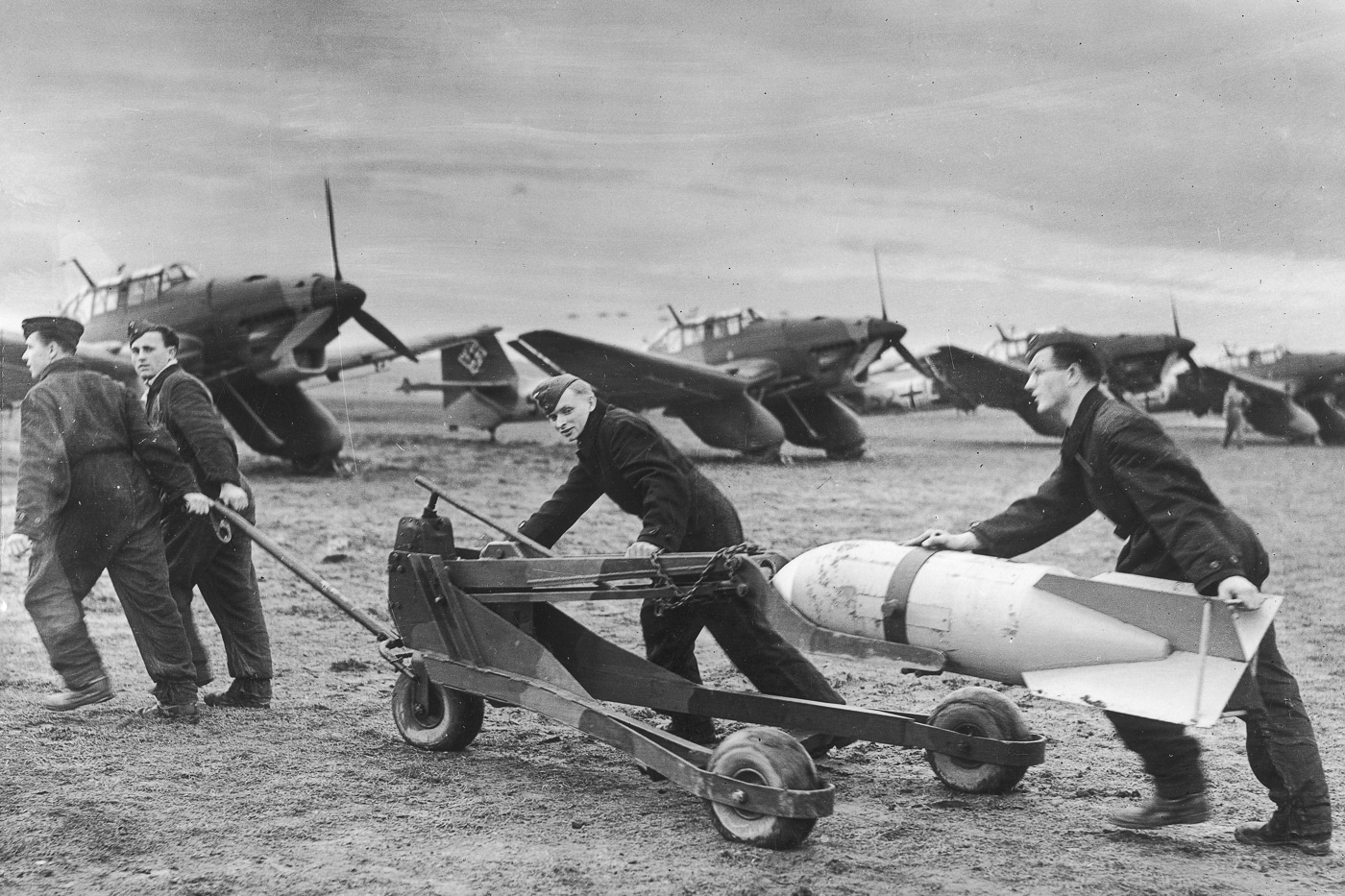 ground crews load a bomb on a Junkers Ju 87A bomber