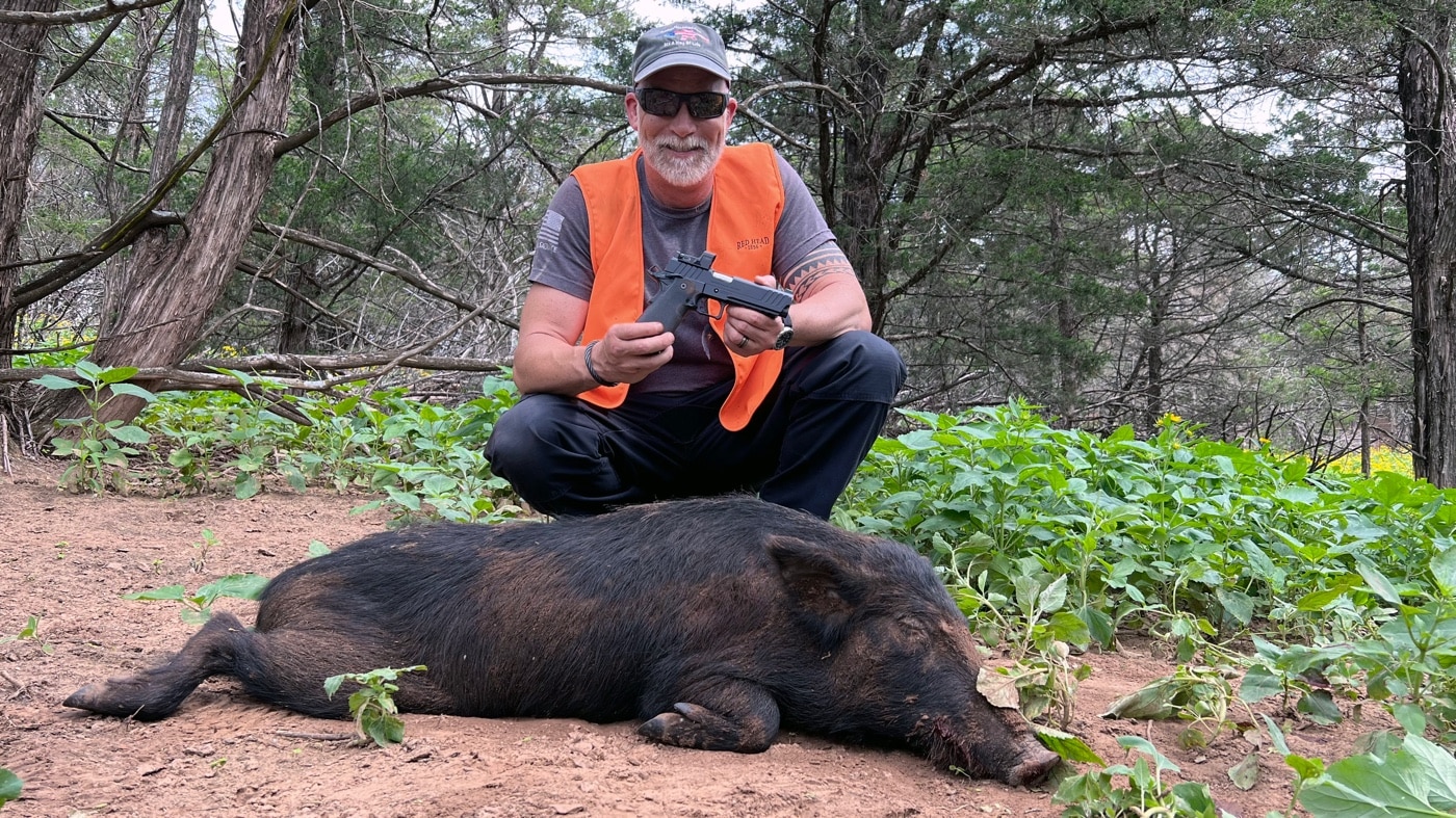In this photo, the author poses with his Springfield Armory Prodigy pistol and the feral hog he harvested during the hunt. The Prodigy is chambered in 9mm, and the author used Federal's Syntech Defense ammo for the hunt.