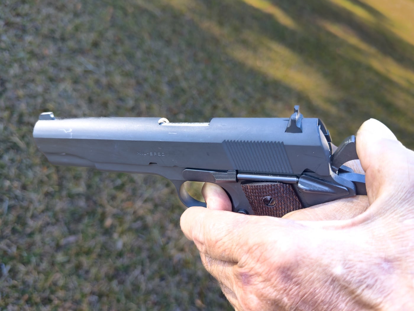 In this photo, the author shows how dangerous it is to try to lower the hammer manually on a M1911 pistol. It would be extremely easy for the weapon owner's thumb to slip off of the hammer and the firing pin strike the primer of the cartridge in the chamber of the handgun. This is not a fail-safe situation and runs the possibility of injury from an unintentional discharge. 