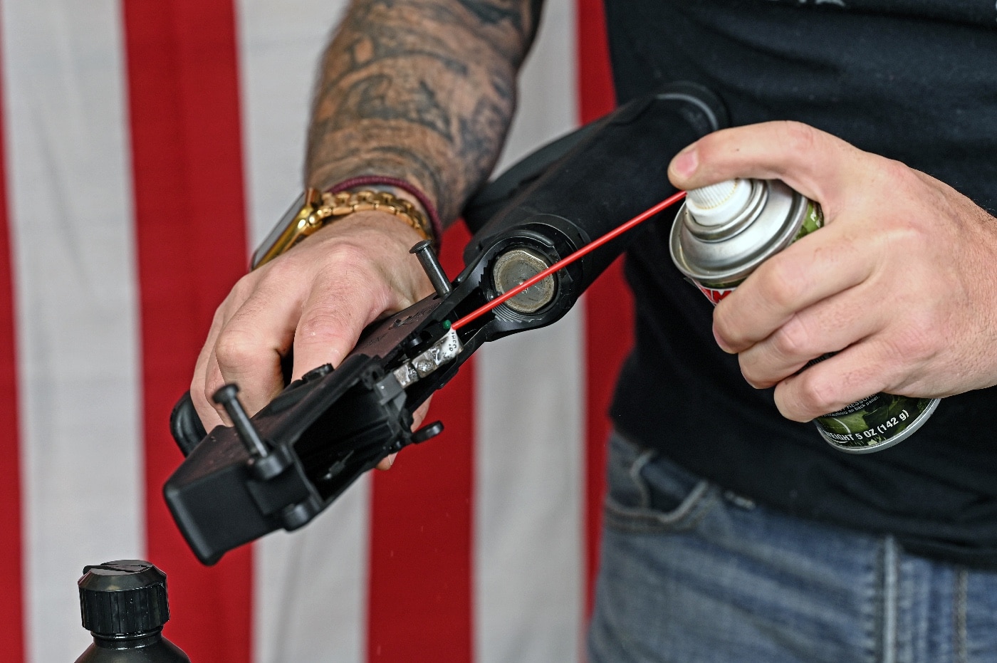In this photo, we see the author applying gun cleaner to the lower receiver of his rifle to help clean it. A rifle is a long-barreled firearm designed for accurate shooting and higher stopping power, with a barrel that has a helical pattern of grooves cut into the bore wall.