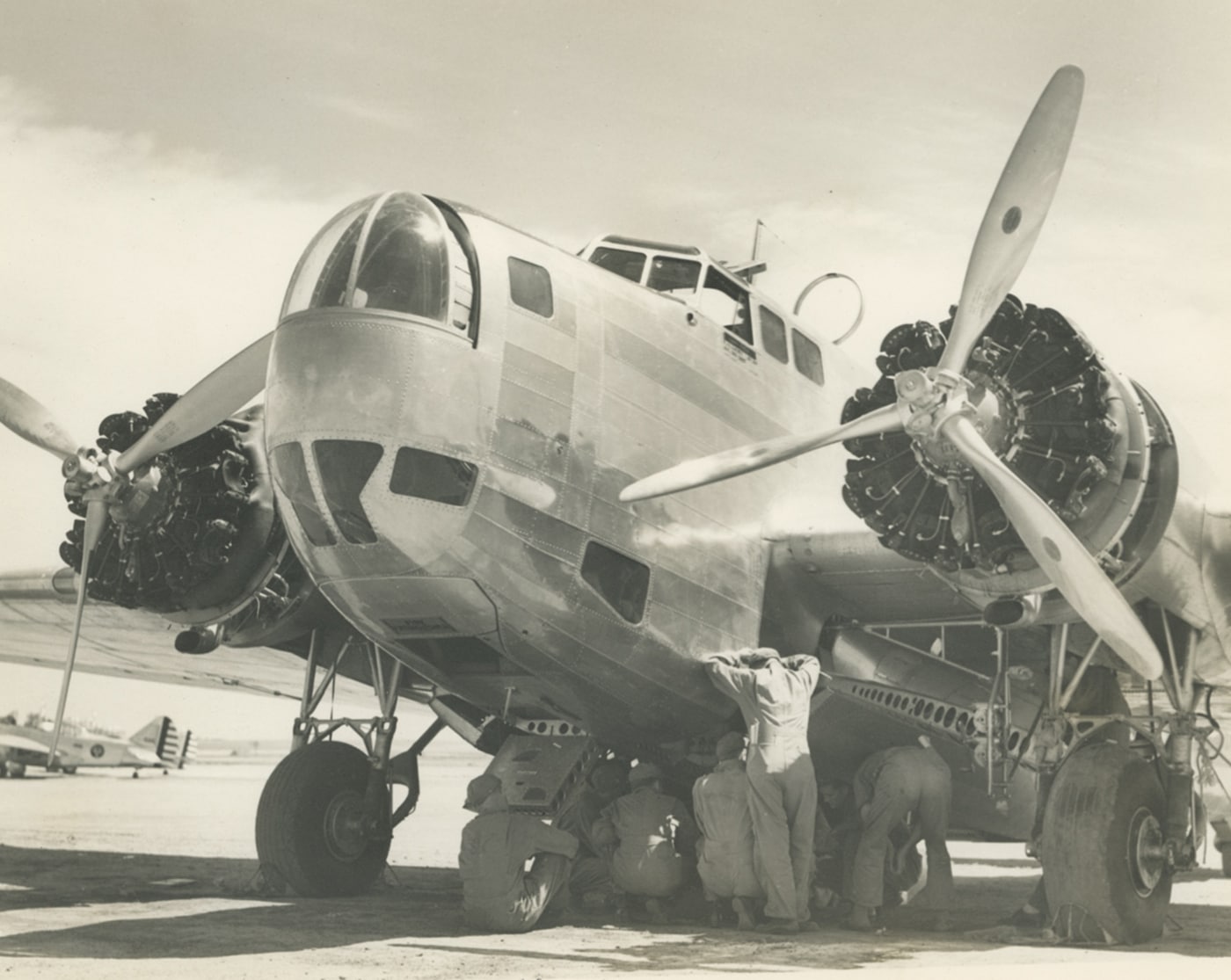 In this photo, we see the front of a B-18 while ground crew members work on the plane. This is an original plane without any variation modifier. By the time the B-18s ended production the country was involved in World War 2, production of all planes had ceased in favor of the more powerful B-17 bomber that offered longer range and a more precise bombardment capability.