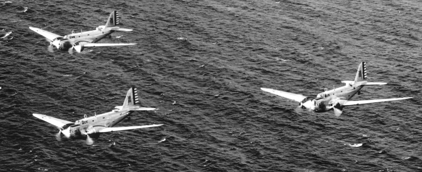 In this image, we see a flight of three B-18 bombers flying over the Pacific Ocean near the Hawaiian Islands in the early 1940s. Although the Boeing B-17 Flying Fortress was a superior bomber in almost every way, the B-18 beat the B-17 to enter production in 1937. By 1941, Boeing was starting to build B-17 bombers to replace the B-18. By the end of the war, virtually no B-18s were still operational, while the B-17 was the real workhorse of the American air power.