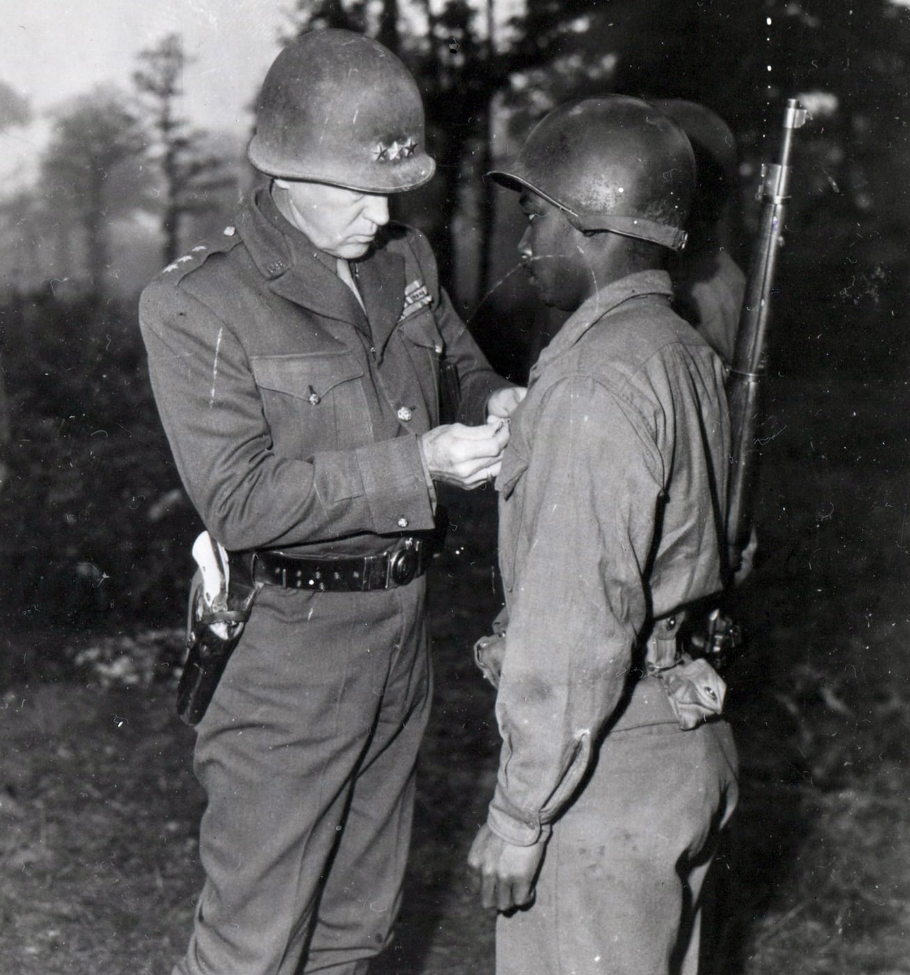 In this image, Gen Patton pins Silver Star on soldier for his heroism in combat. 