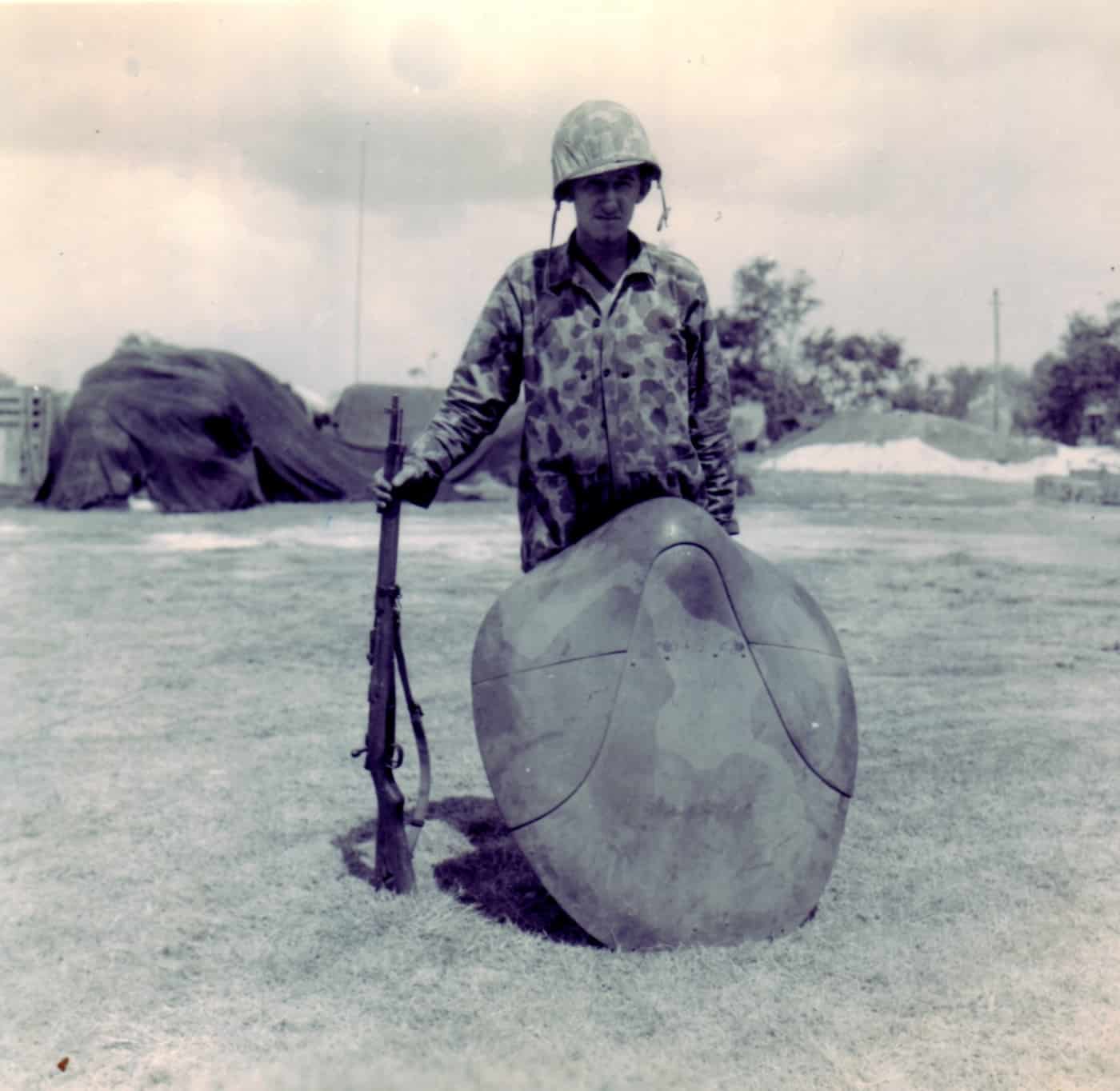 In this photo we see a United States Marine with a Japanese turtle shell cape that was designed to stop bullets and was also capable of stopping flak and debris.