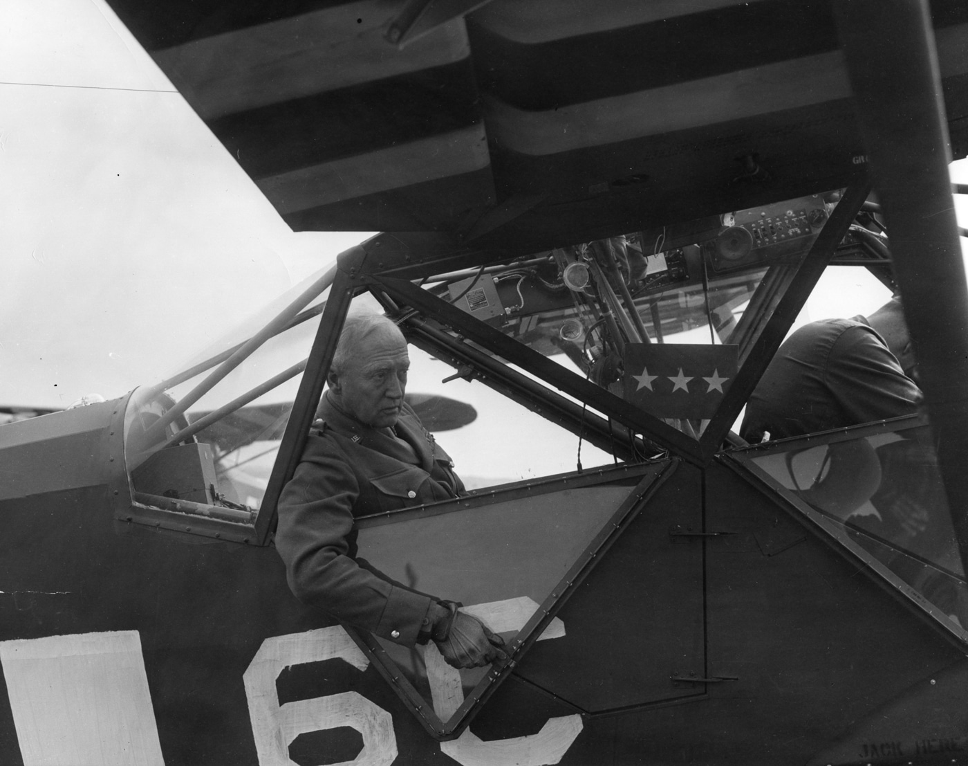 In this photograph, Lt Gen George Patton is seated in an observation plane. He is preparing to take to the air for a better view of the battlefield.