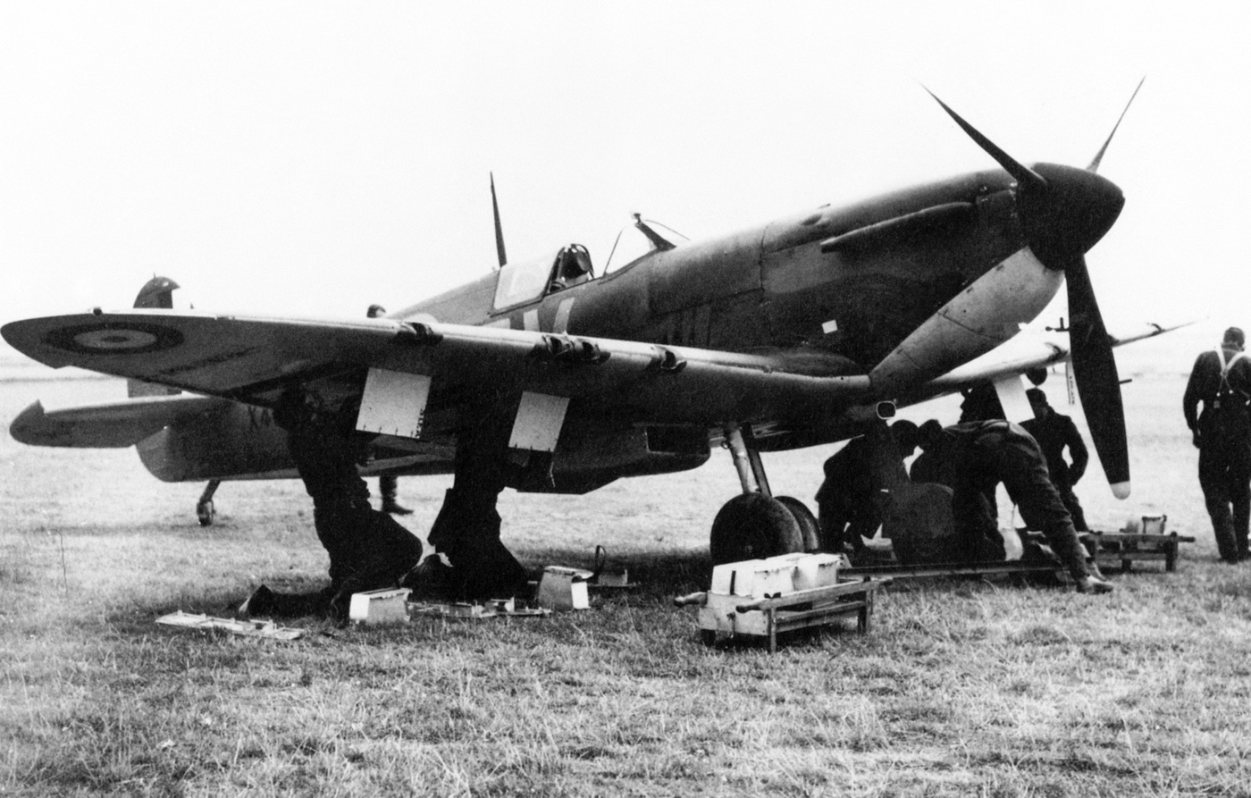 In this early photograph from World War II, ground crews rush to rearm a Supermarine Spitfire Mk I so it can intercept German bombers over England.