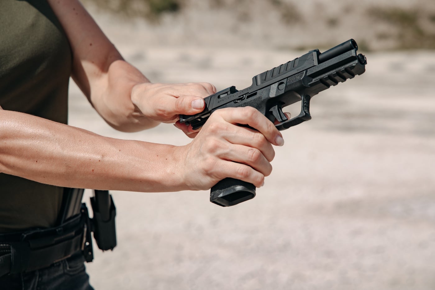In this digital image, we see a shooter operating the pistol slide using the slingshot or pinch method.