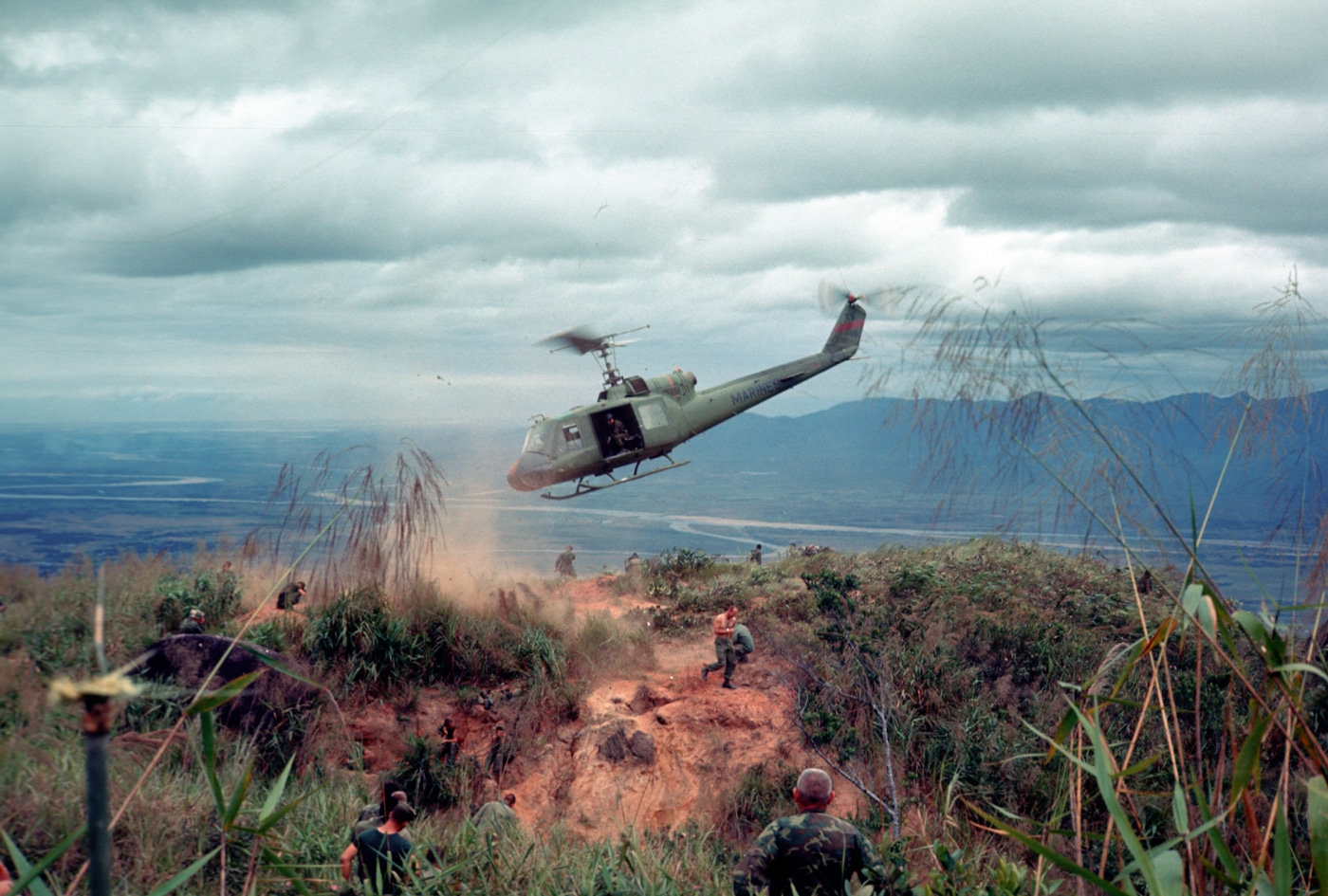 In this photograph, we see the most-produced version of the Iroquois military helicopter deliver ammunition, grenades and rations to United States Marines during Operation Oklahoma Hills during the Vietnam War. The helicopter used air mobility as its strength in supporting ground troops and could carry a large amount of munitions.