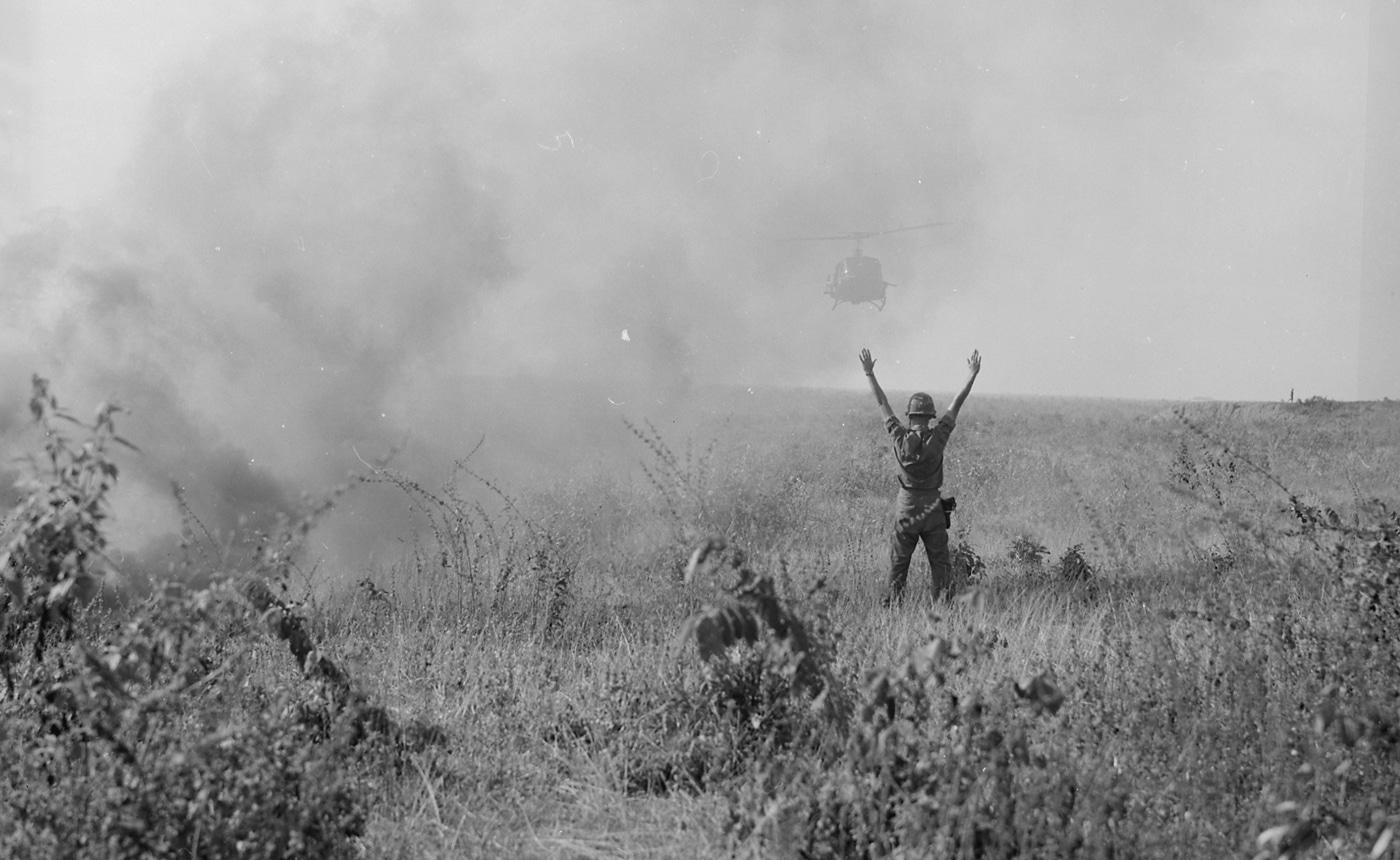 In this photograph, an American soldier — an forward air traffic controller — directs a medical aviation helicopter into a landing zone. A national guard soldier had been injured during a battalion parachute drop in the Republic of Vietnam.