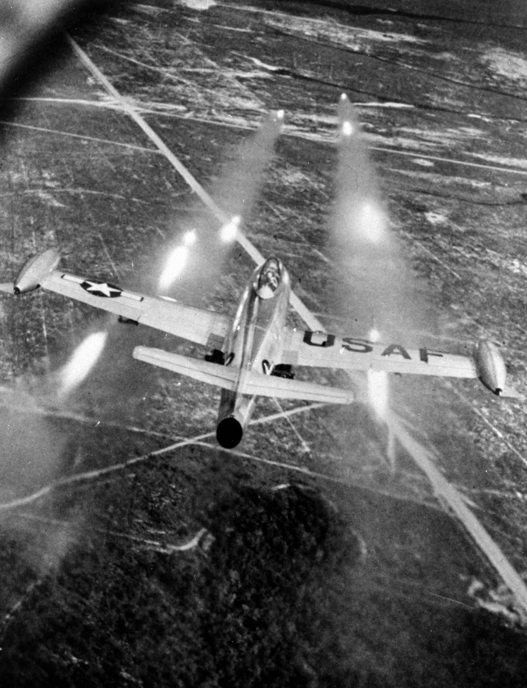 F-84 fires rockets at a ground target