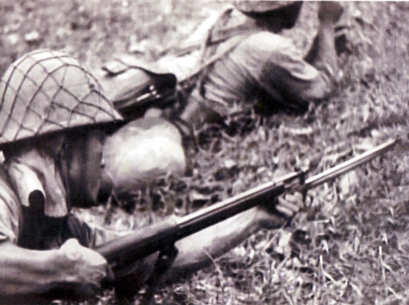 In this digital image, we see a Japanese soldier attaching a Type 30 bayonet to his rifle during a battle in the Pacific Theater.