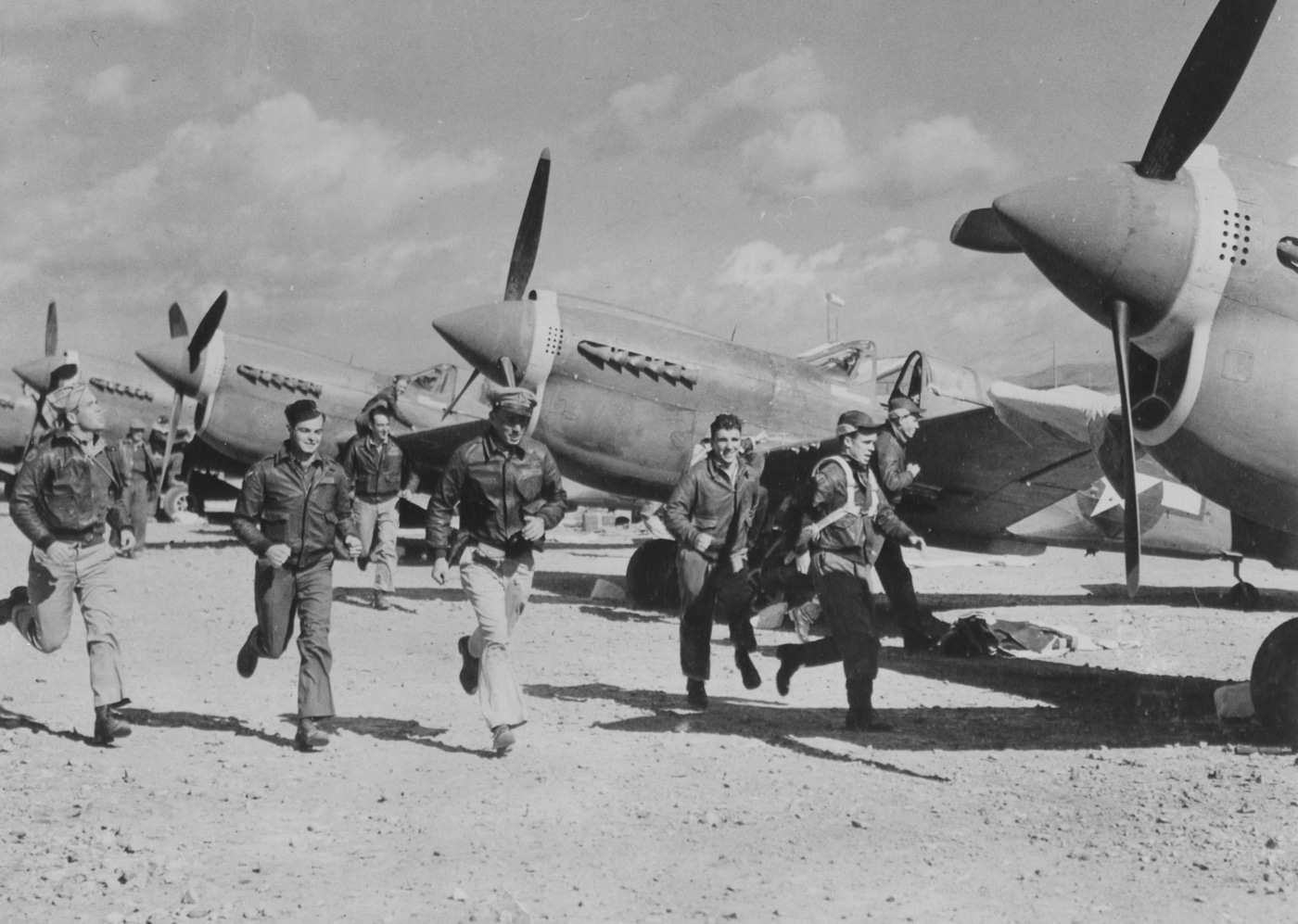 P-40 pilots run to their planes during an air raid