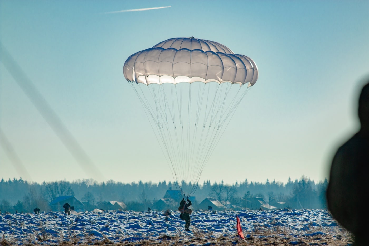In this image, a Russian paratrooper lands in a snow covered field during training. Russian paratroopers battled Ukrainian forces to capture the Antonov airfield. The Russian troops were supported by Russian helicopters including the Ka-51 Alligator.