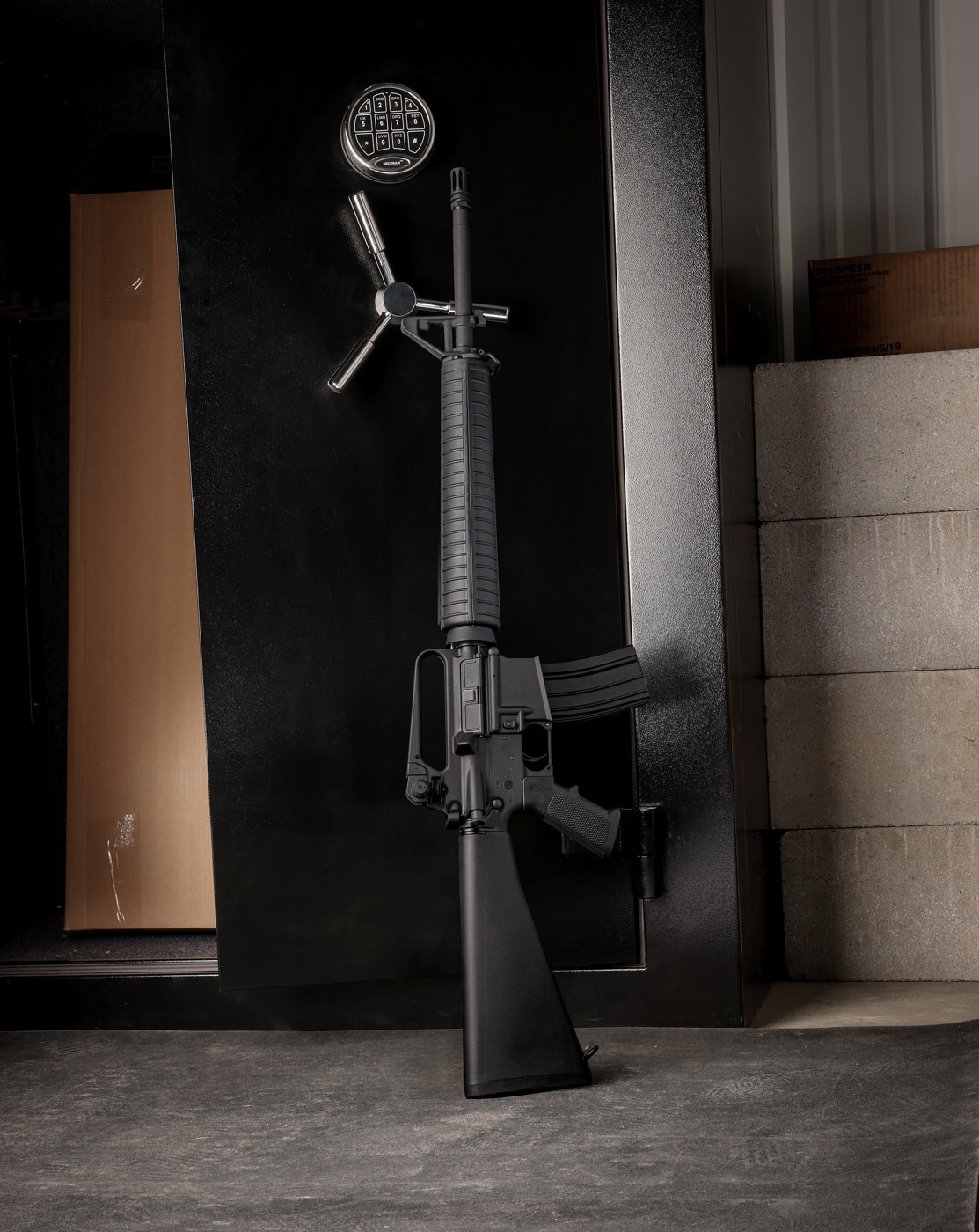 In this digital photo, we see a Springfield SA-16A2 rifle leaning against a gun safe.