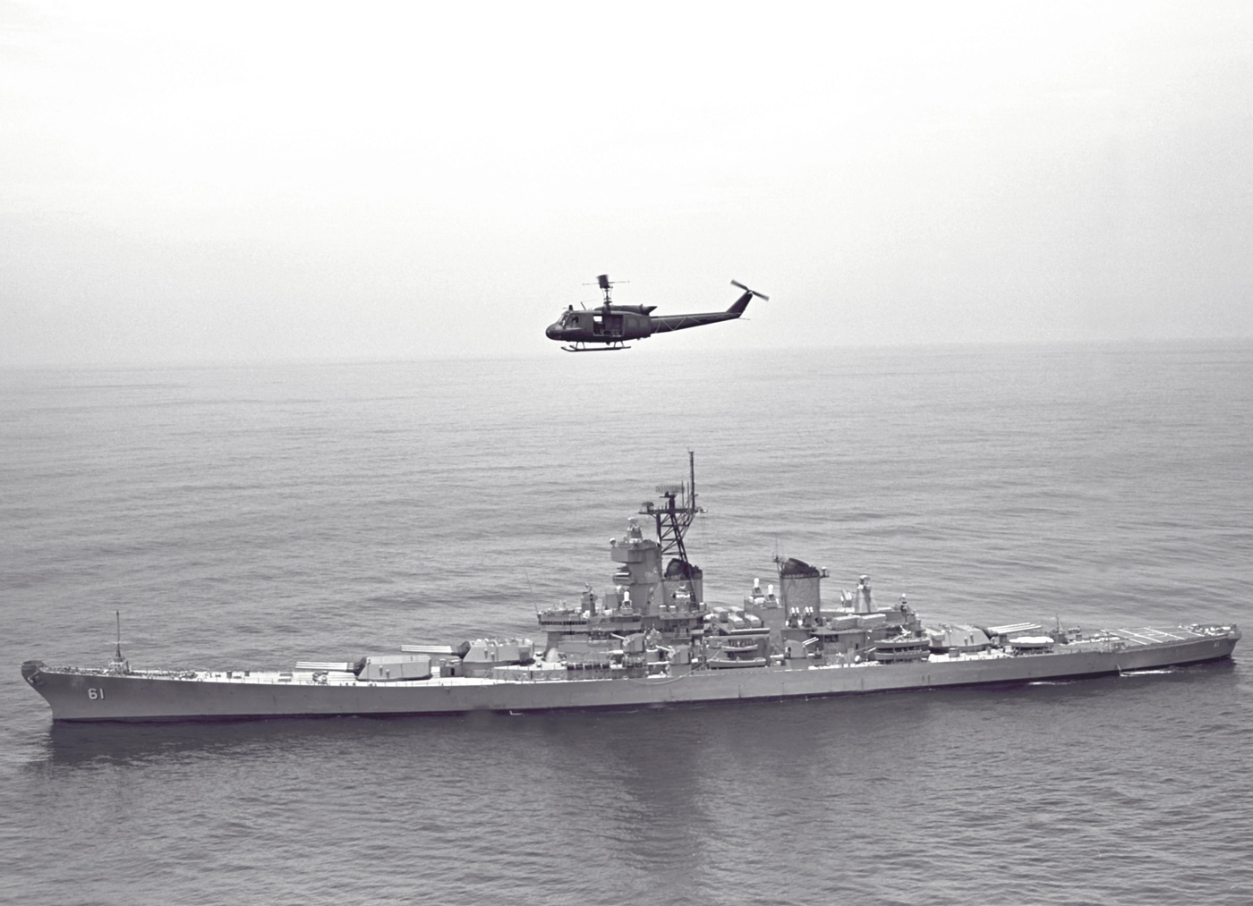 In this digital image, we see a UH-1 Iroquois helicopter as it flies over the battleship USS Iowa (BB-61) during its shakedown cruise in 1984. The Iowa had been modernized and returned to service to counter the Soviet Union during the President Ronald Reagan Administration.