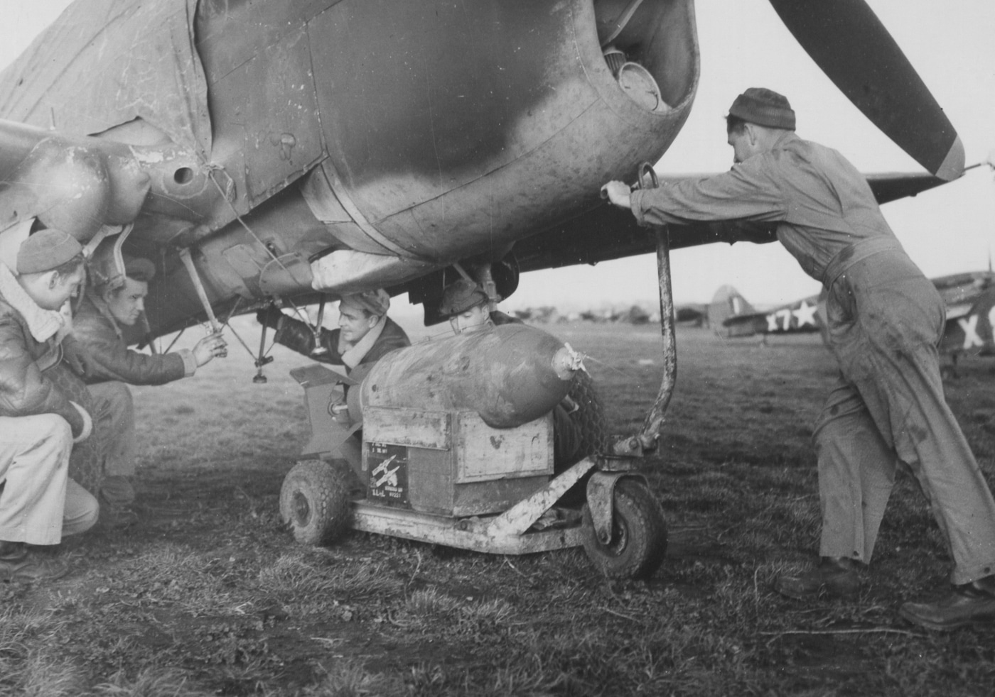 ground crews load a 500 lb bomb on P40