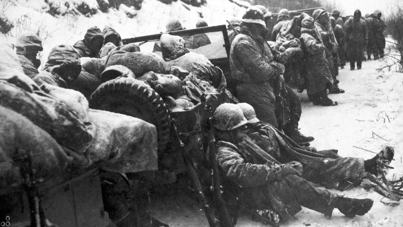 In this images, we see U.S. Marines of 1stMarDiv during the Battle of Chosin Reservoir. They are resting in the snow along the roadway.