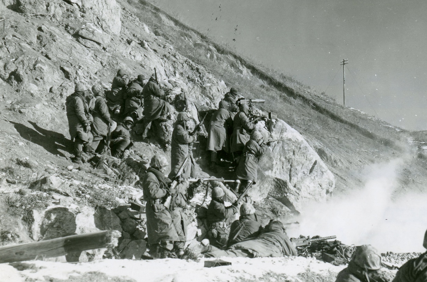 In this photo, we see Marines engage a Chinese roadblock near Hagaru-ri on December 6, 1950. The Marines helped evacuate UN forces including those from the X Corps Eith Army and others around Chosin.