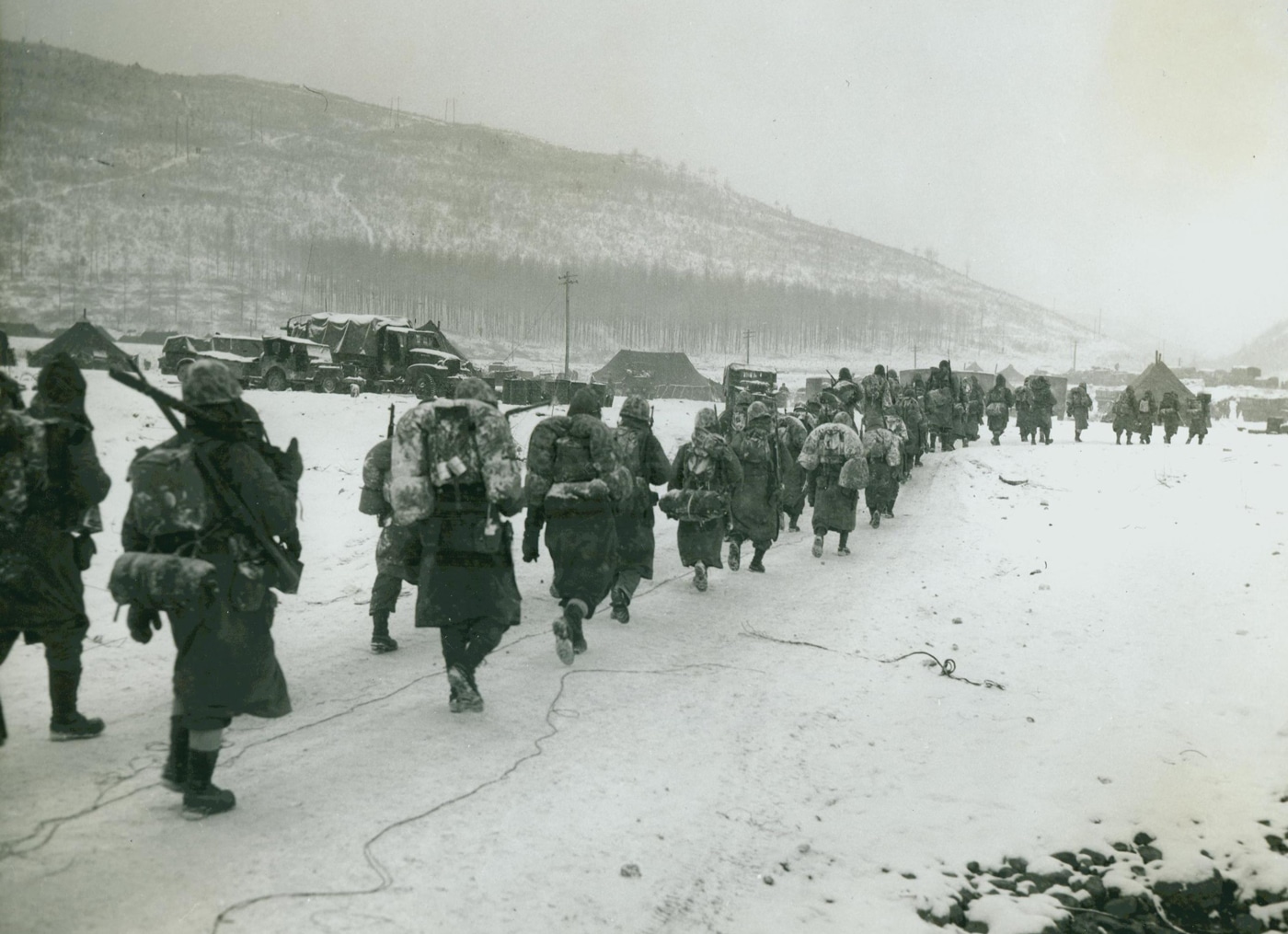 In this photograph, U.S. Marines march through the snow. Part of a regimental combat team under General Douglas MacArthur, the Marines both received and inflicted heavy casualties. The numbers of Chinese communist forces entered the combat with a 4:1 advantage. They suffered about 50% losses due to the tenacity of the UN forces.